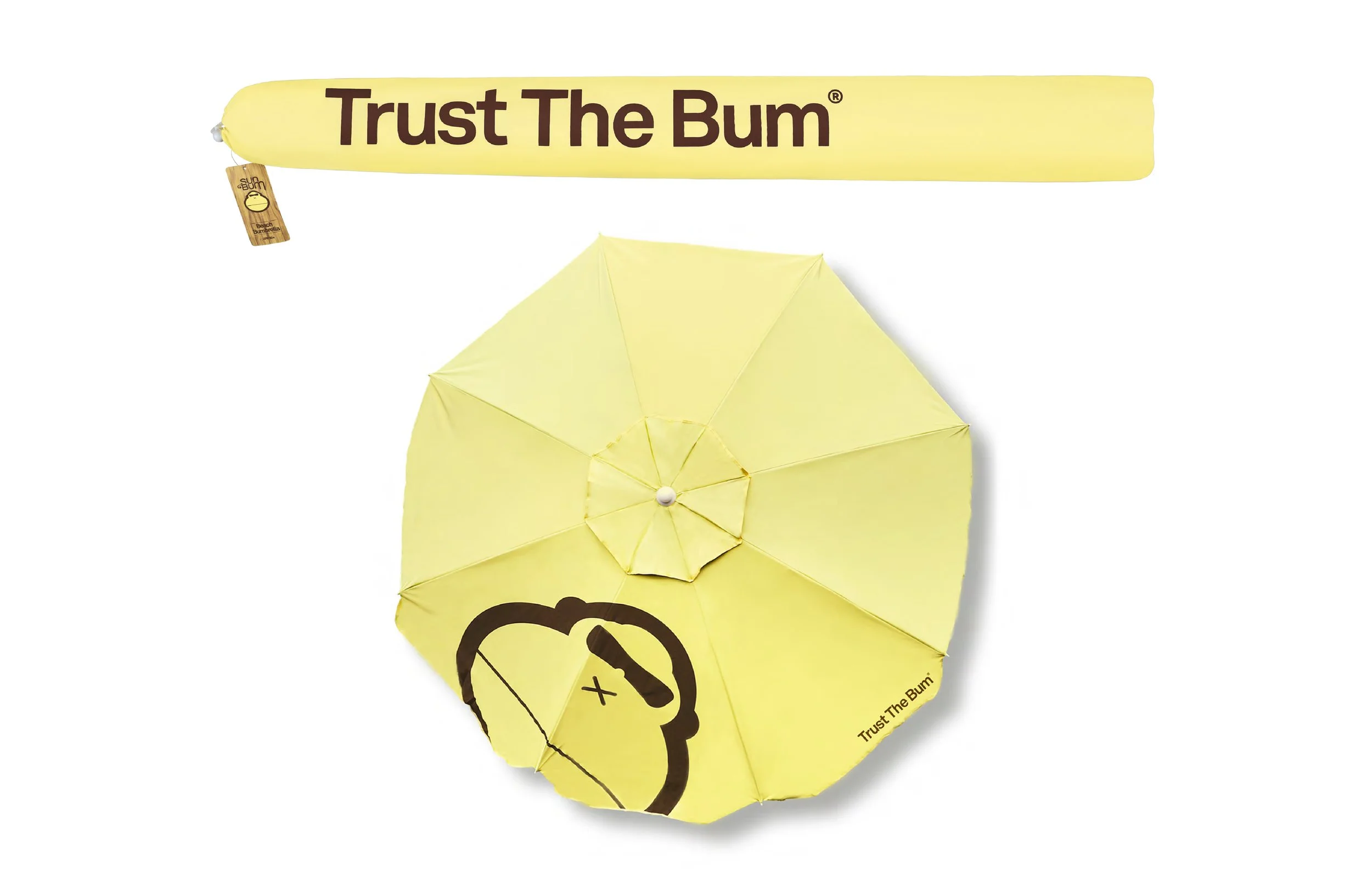 Yellow umbrella with a black smiley face and text 'Trust The Bum' printed on it