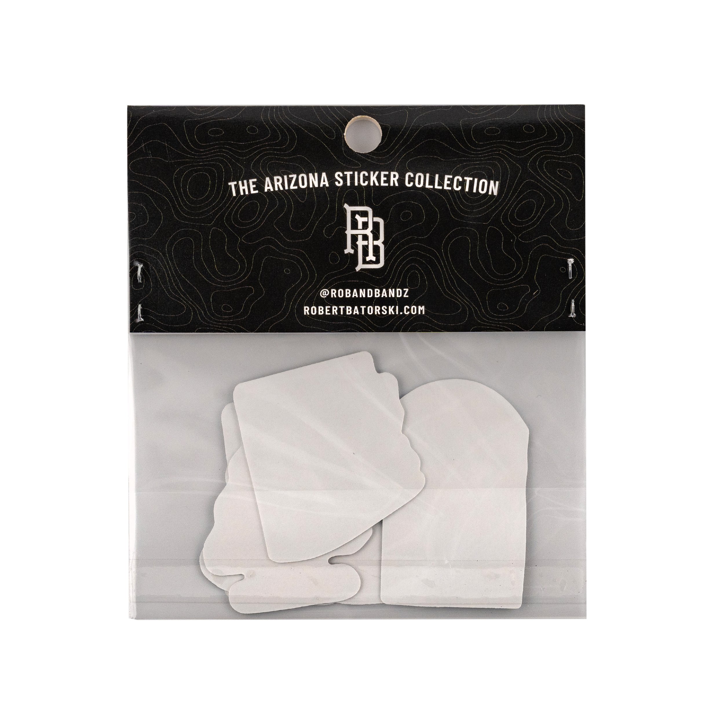 A black cardboard display board with the text 'The Arizona Sticker Collection' and social media handle '@ROBANDBANDZ' along with a website 'ROBERTBATORSKI.COM'. The background has a topographical map pattern, and the board is tilted against a white s
