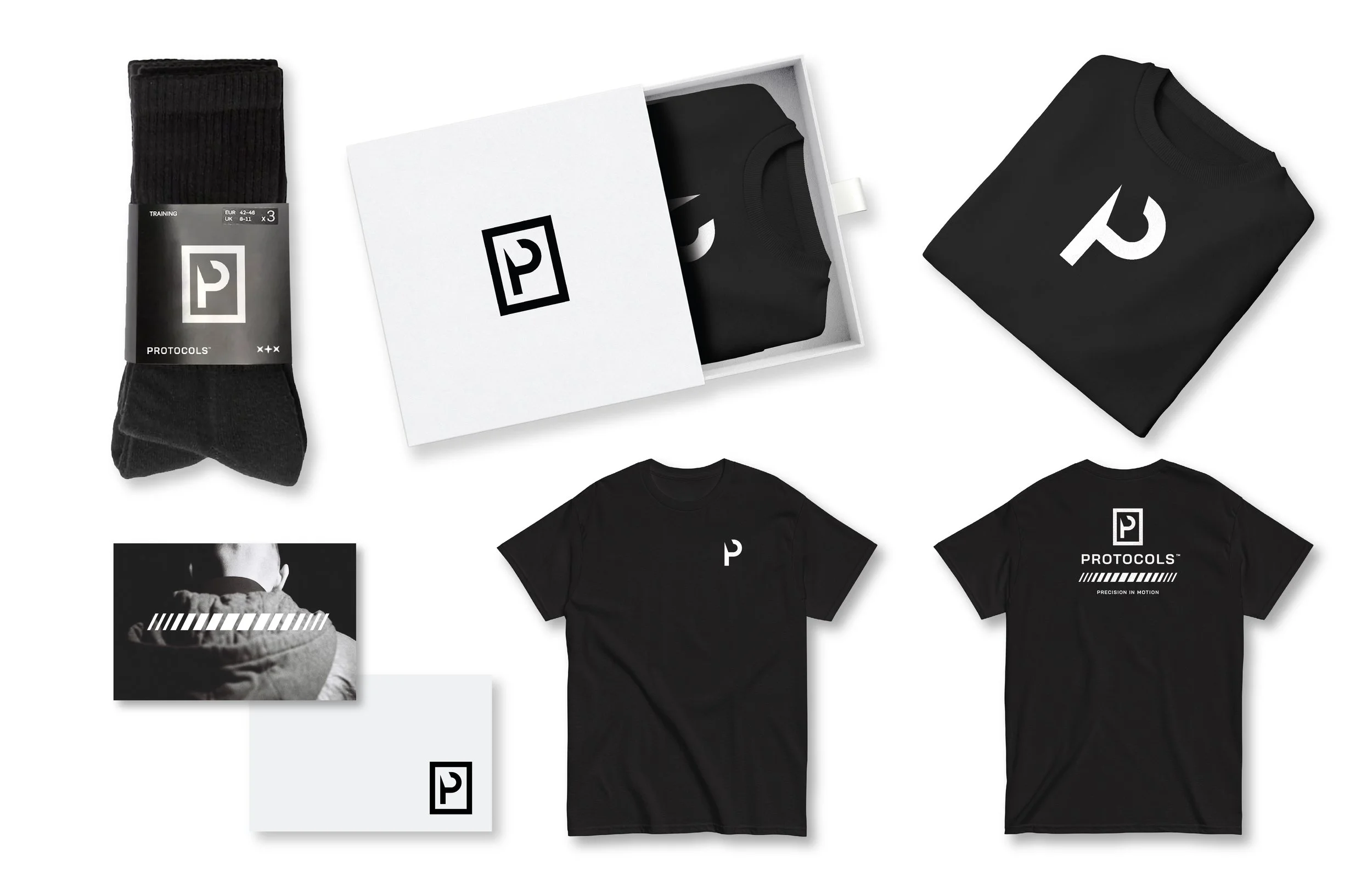 Black socks, black t-shirts with white logo, and packaging box with logo, arranged on a white background.