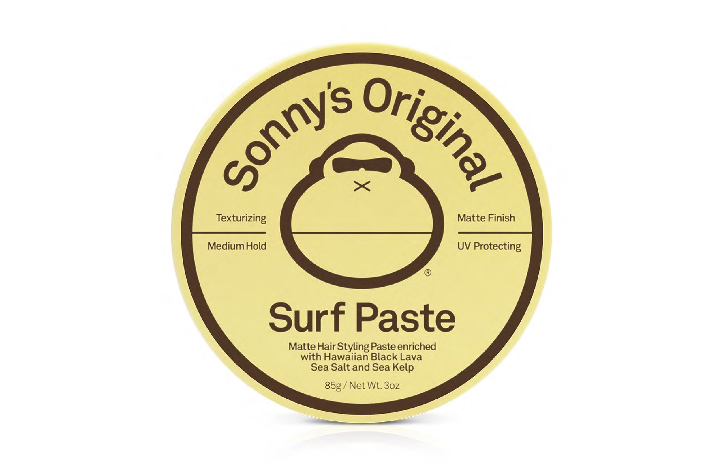 Label for Sonny's Original Surf Paste, featuring a circular design with brown text on a yellow background. Highlights include texturizing, medium hold, matte finish, UV protection, and ingredients like Hawaiian Black Lava, Sea Salt, and Sea Kelp.