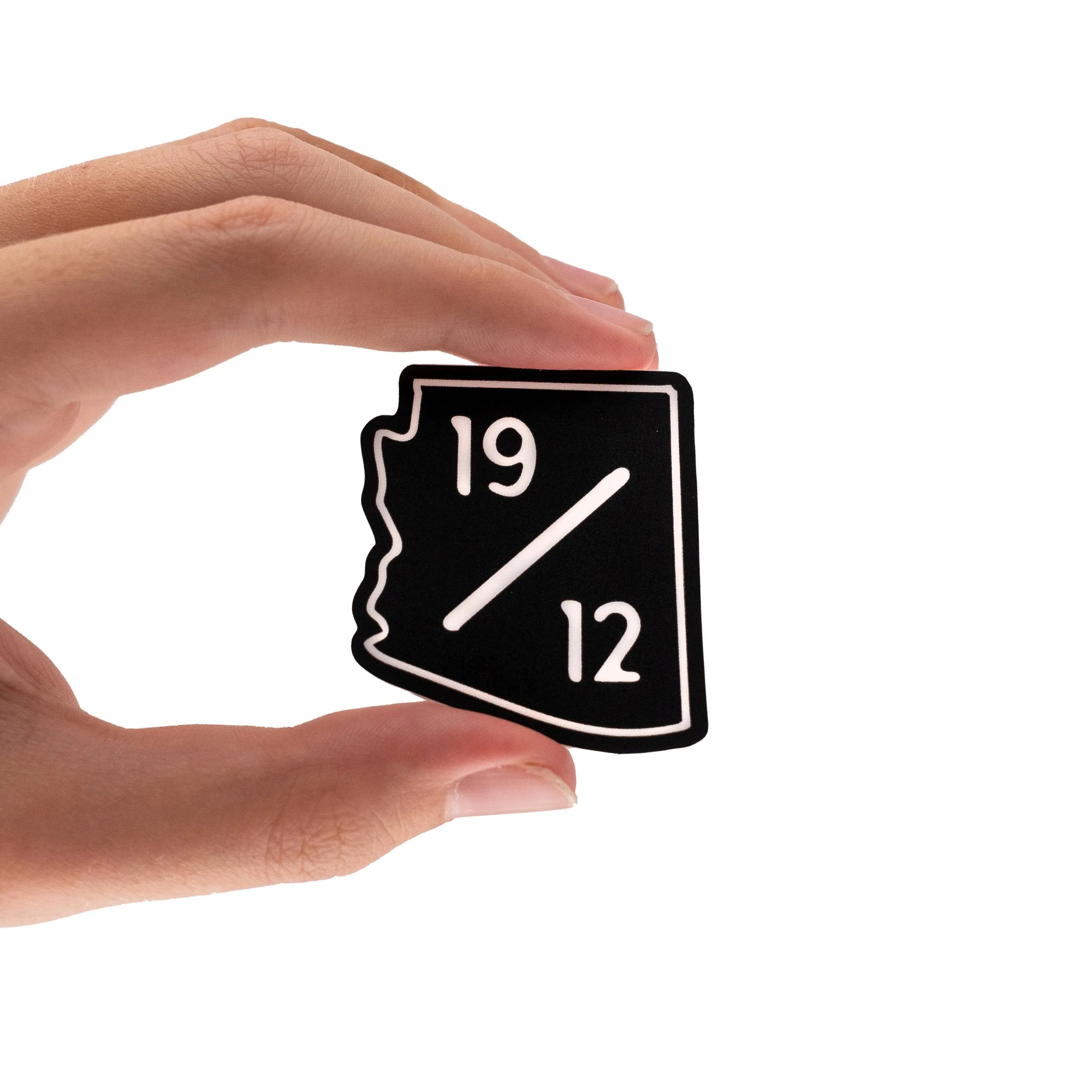 A person's hand holding a black and white road sign with the number 19.