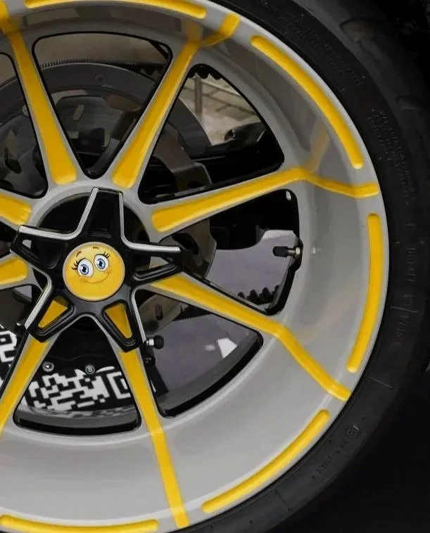 Produktaufnahme Harley-Davidson Würzburg Village Stand in Faak am See Österreich von einem Detail des dekorierten Leichtmetallrads mit gelben Akzenten, schwarzer Sternspeiche und Smiley-Nabenkappe