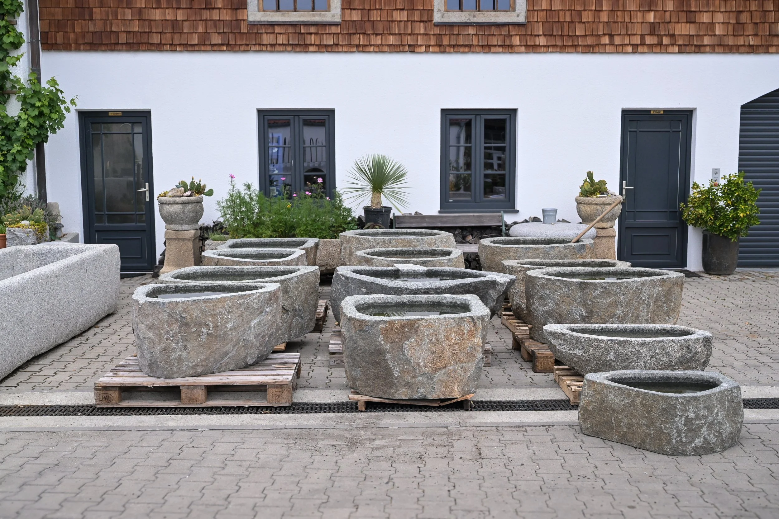 Produktfotografie Czernei Natursteinhandel: Natursteintröge und Pflanzgefäße im Außenbereich.