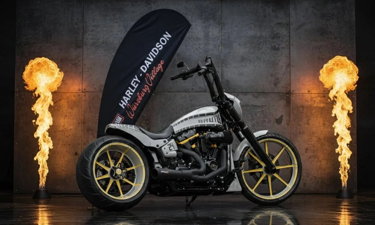 Individuell gestaltetes Harley-Davidson-Motorrad mit goldenen Felgen vor dunkler Metallwand und Flammensäulen