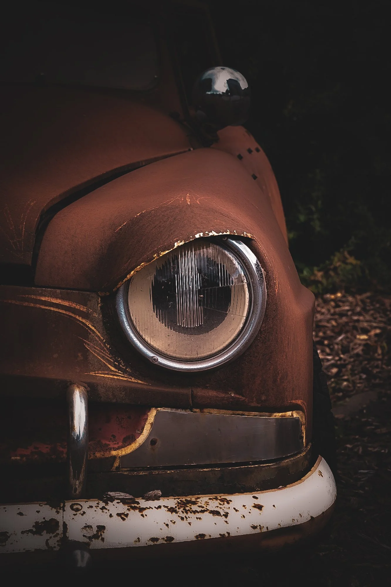 Automotivefotografie: Detailaufnahme des chromgefassten Frontscheinwerfers eines amerikanischen Oldtimers aus den 1960er-Jahren.“