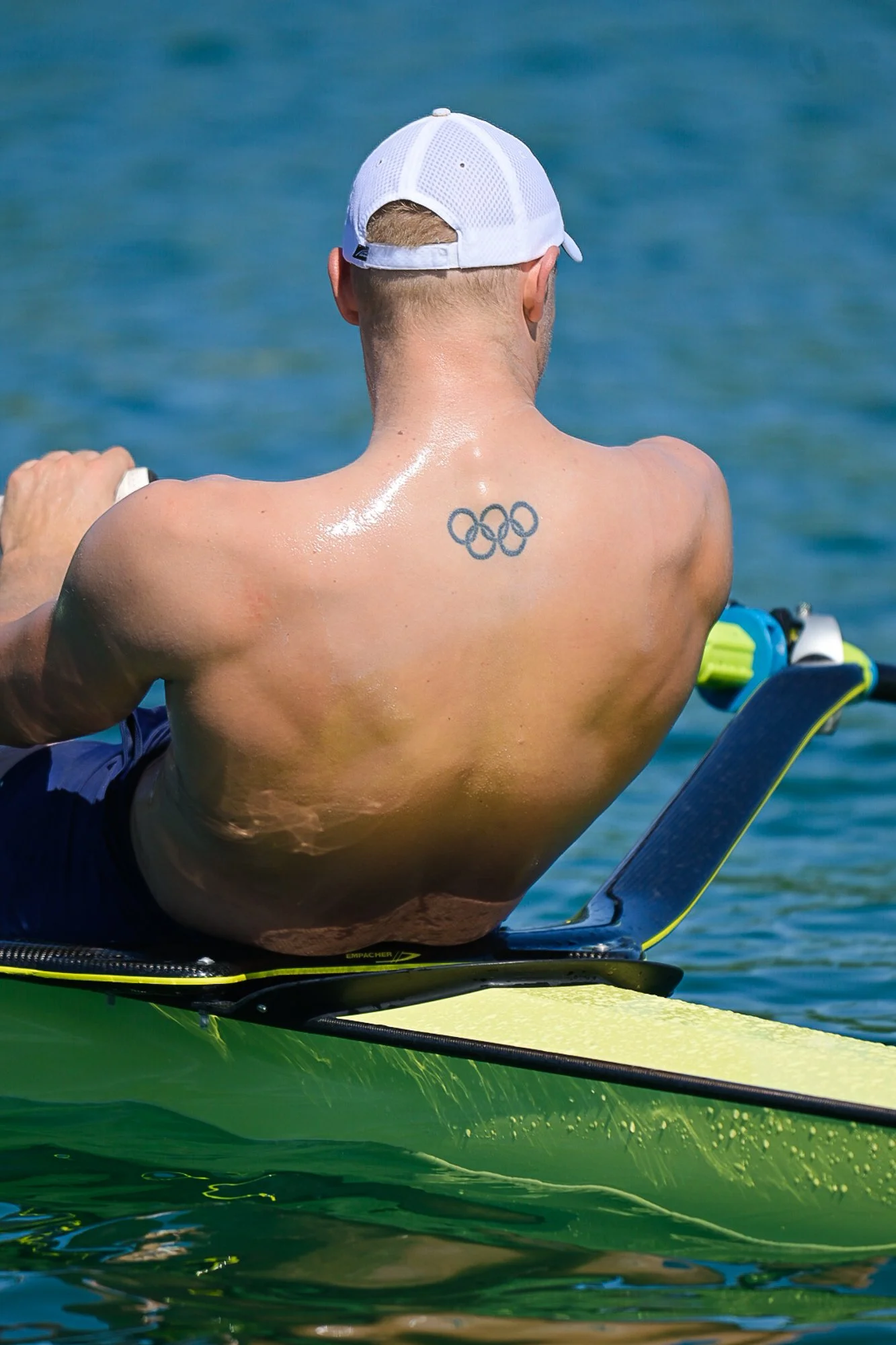 Sportlerporträt: Ruder-Olympiasieger Oliver Zeidler im Einer, mit olympischen Ringen auf dem Rücken.