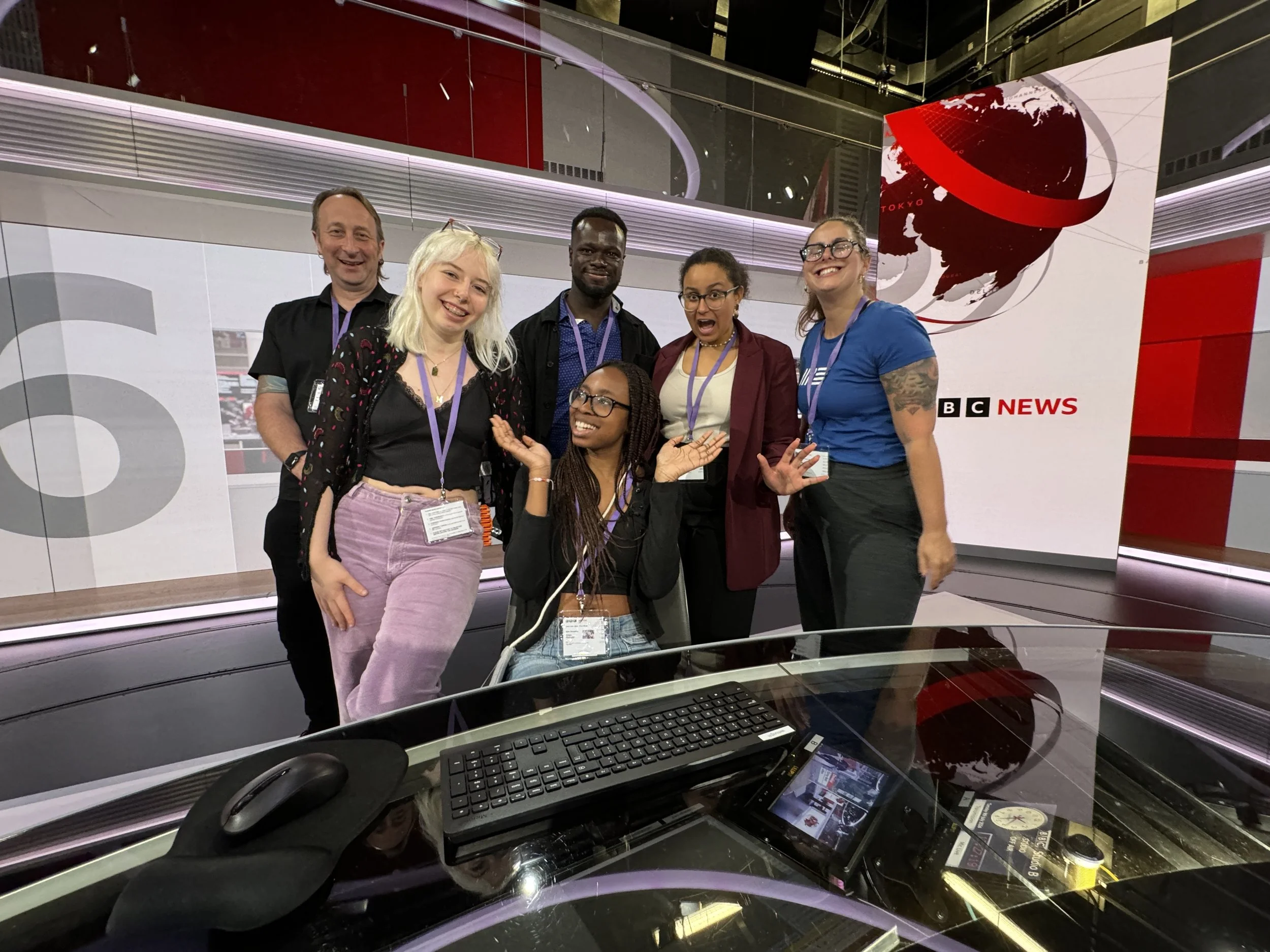 Team photo at a BBC News event — smiling participants framed by studio lighting and broadcast graphics, capturing a moment of collaboration and media innovation.