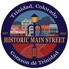 Seal of Trinidad, Colorado featuring historic buildings, a streetlamp, and a brick sidewalk with the text 'Est. 2011, Historic Main Street, Corazon de Trinidad'.