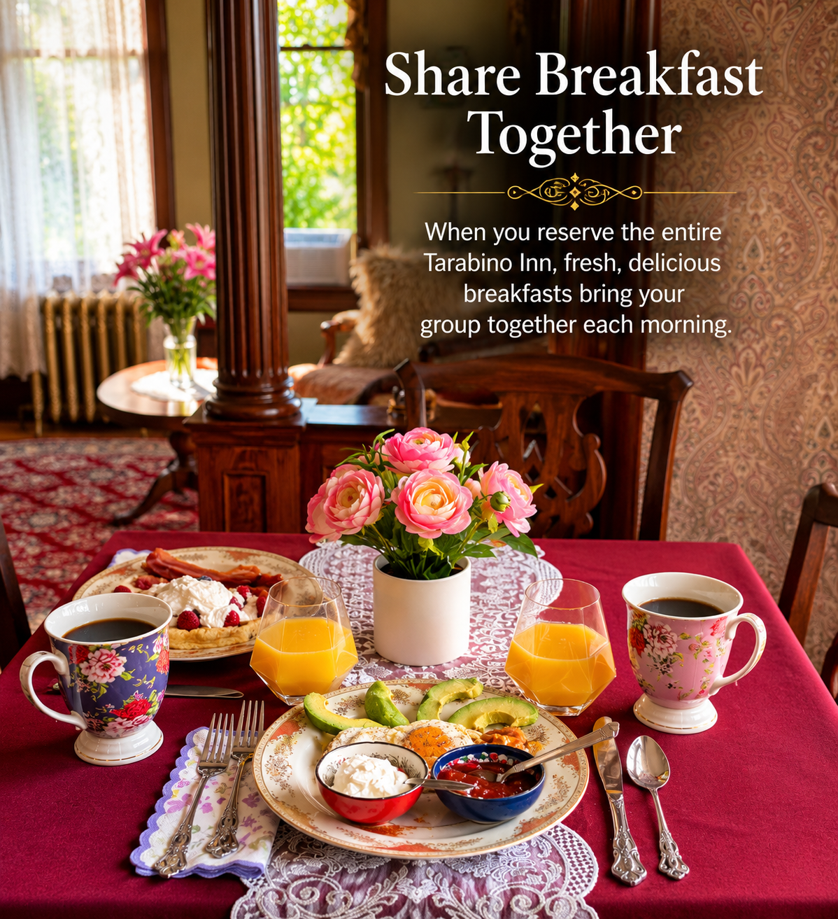 A breakfast table with pink flowers, two cups of coffee, orange juice, and a variety of breakfast foods including fruit, yogurt, and pancakes in a cozy, vintage-style dining room.