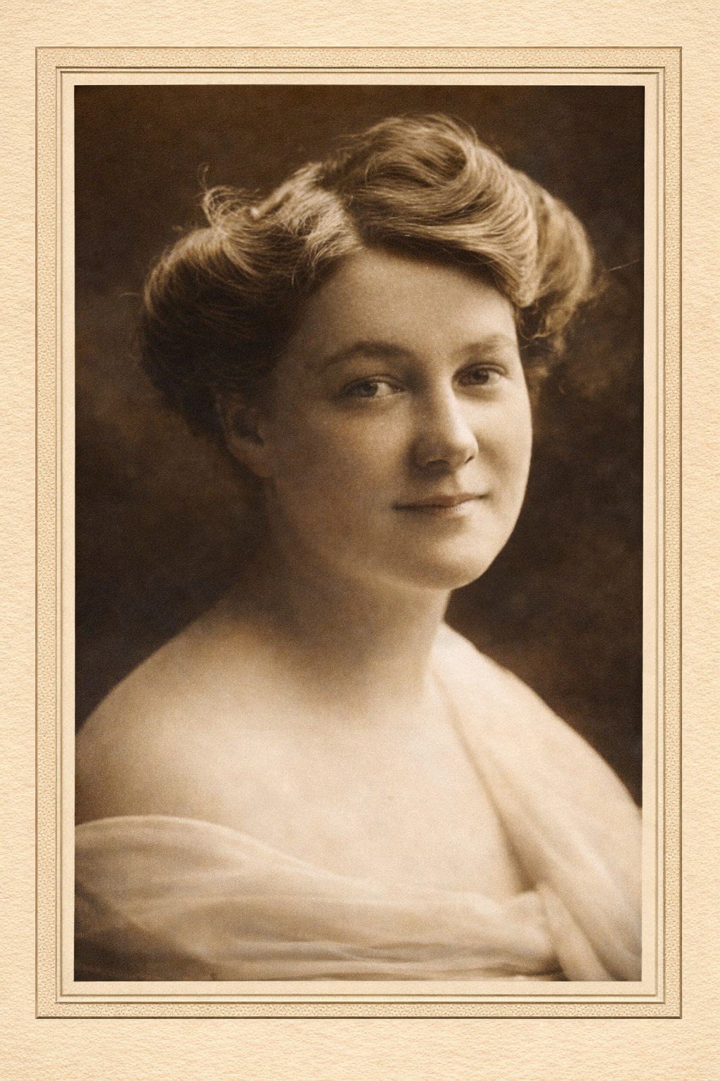 Black and white portrait of a woman with styled hair, looking slightly to the side, wearing a light-colored off-the-shoulder garment.