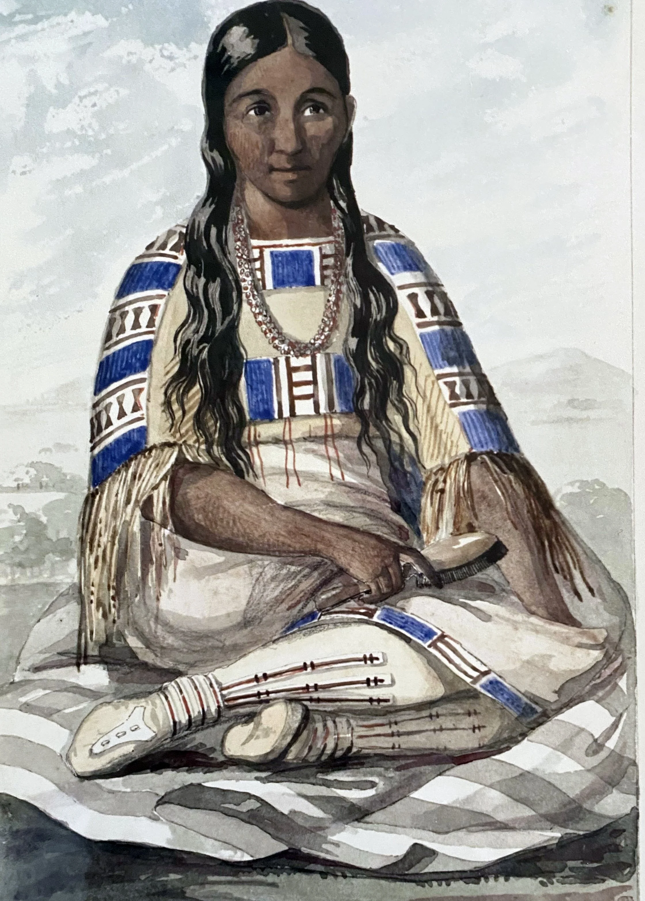 Painting of a woman with long black hair, sitting cross-legged with arms crossed, wearing traditional patterned clothing with blue, white, and brown details, set against a gray background.