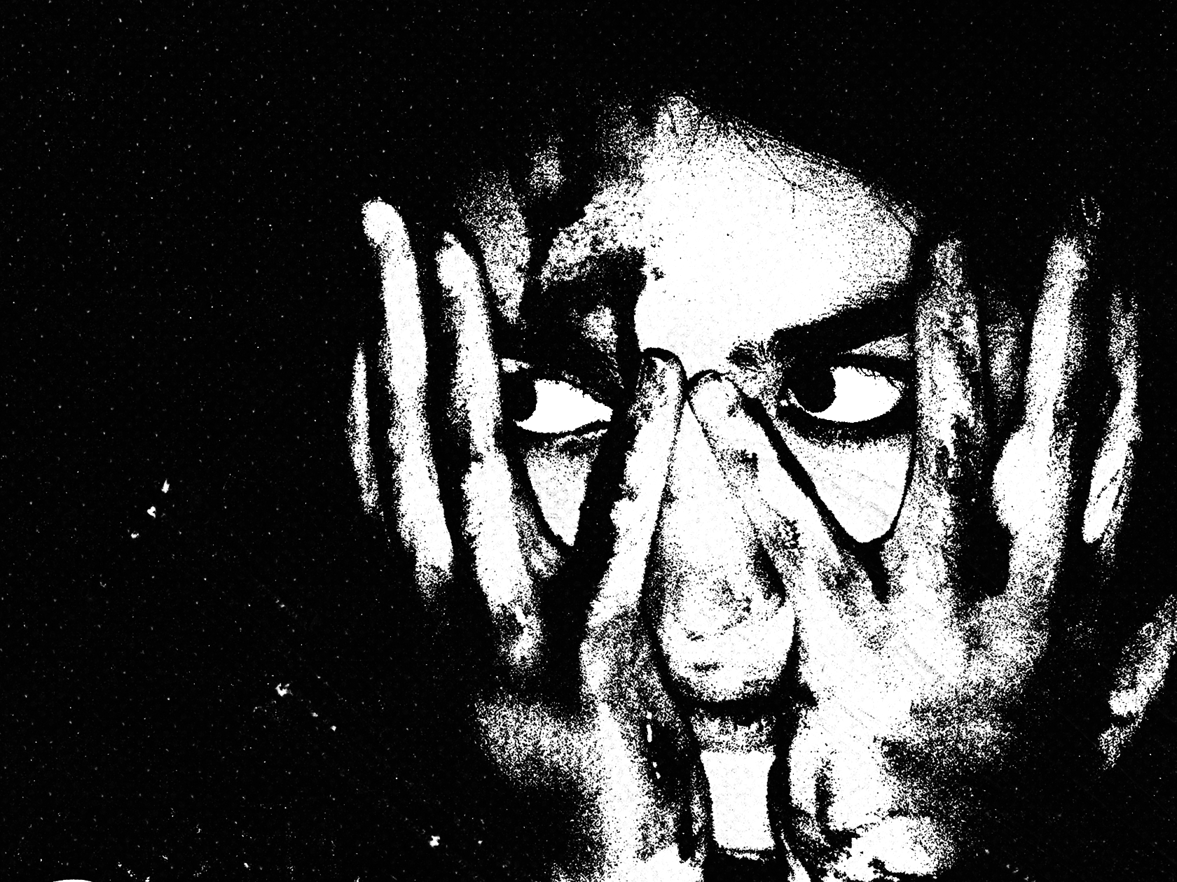 Black and white artistic image of a person with glasses, looking through fingers placed around their face in a distressed pose.