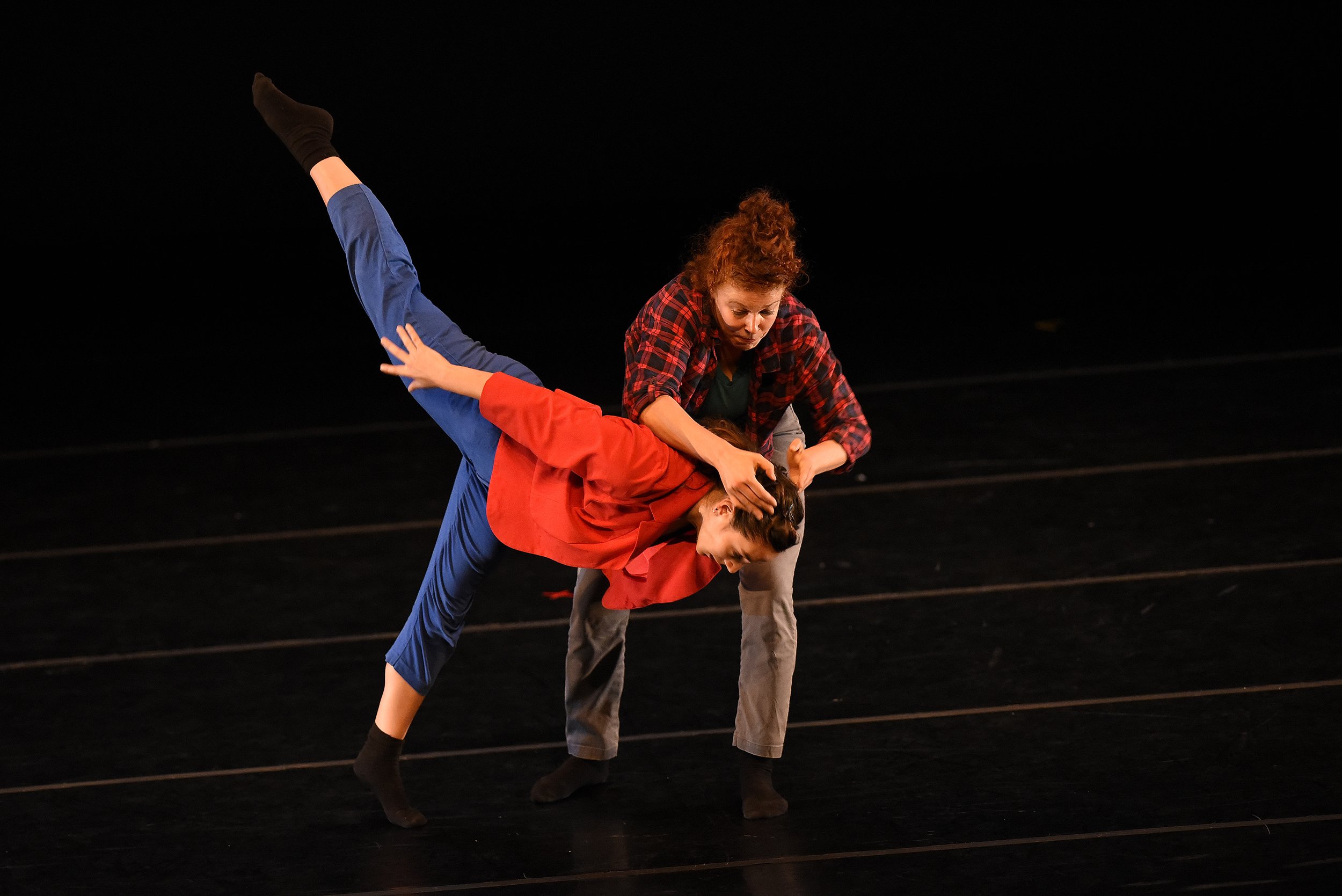 Anna and Leah dance together onstage. Leah supports Anna's head while Anna is in a tilted arabesque position.