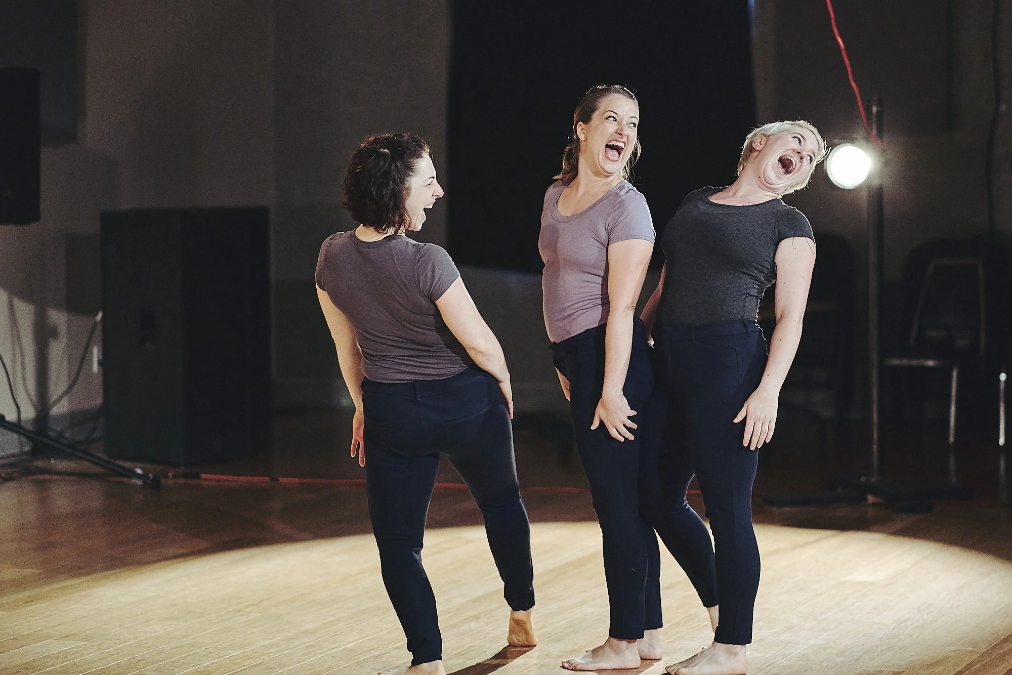 Alyssa Noble, Stephanie Woodbeck, and Allie Pfeffer look over their shoulders, smiling maniacally.