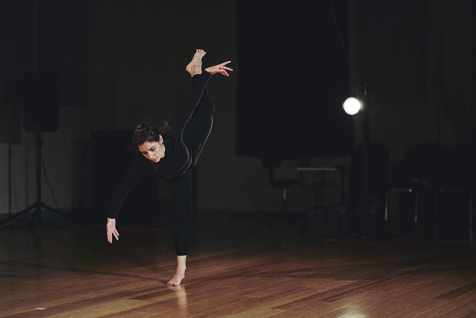 Anna wears all black. She does a penché arabesque.