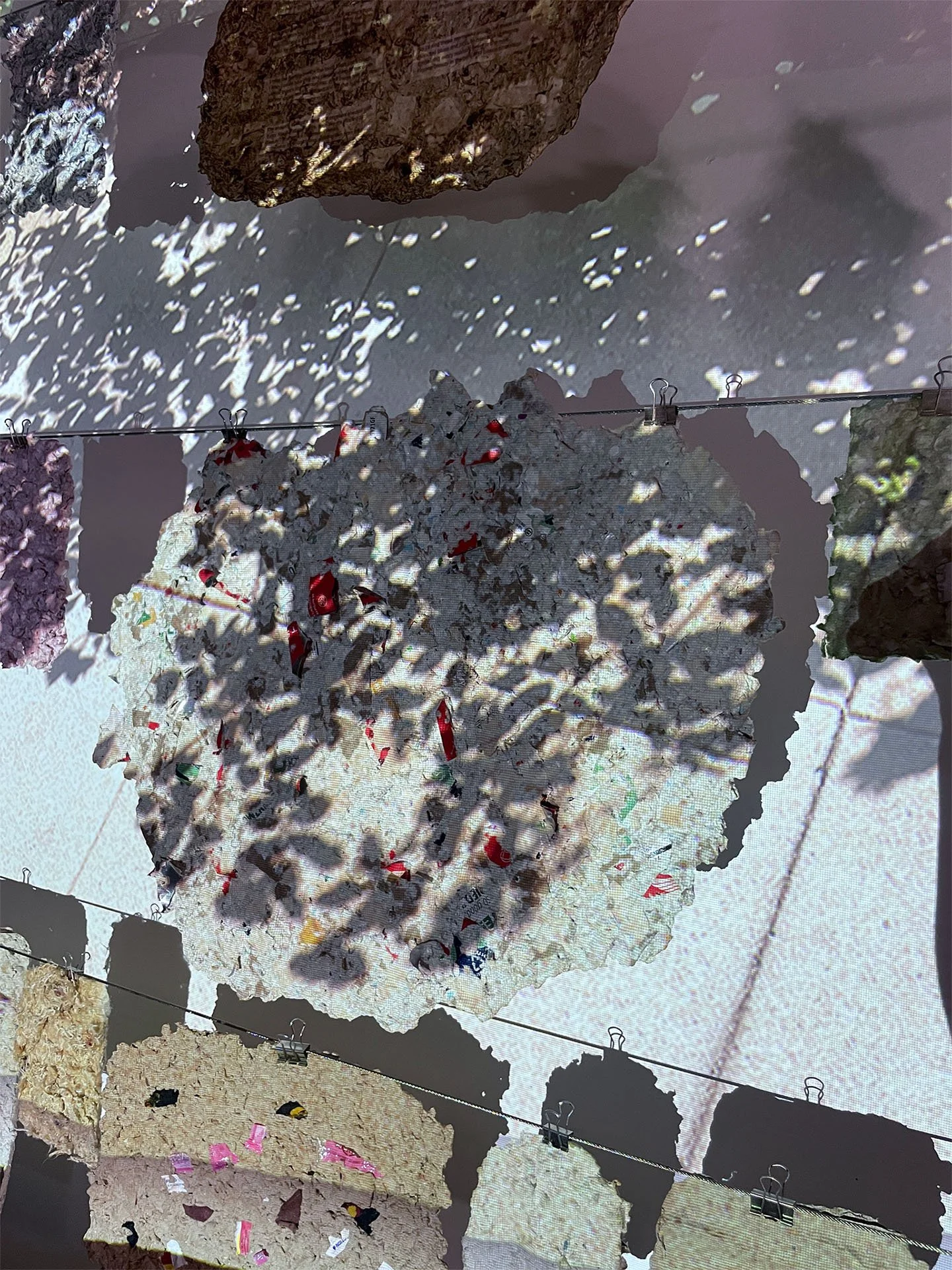 Fleeting Beauty (detail), 2022-2026, Pulp from packaging, clothing fibers, flowers, projection, dimensions variable