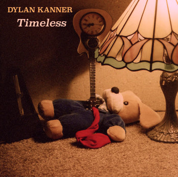 A teddy bear lying on the carpet with a red bow tie, a lamp with a stained glass shade, and a vintage clock in a dimly lit room.