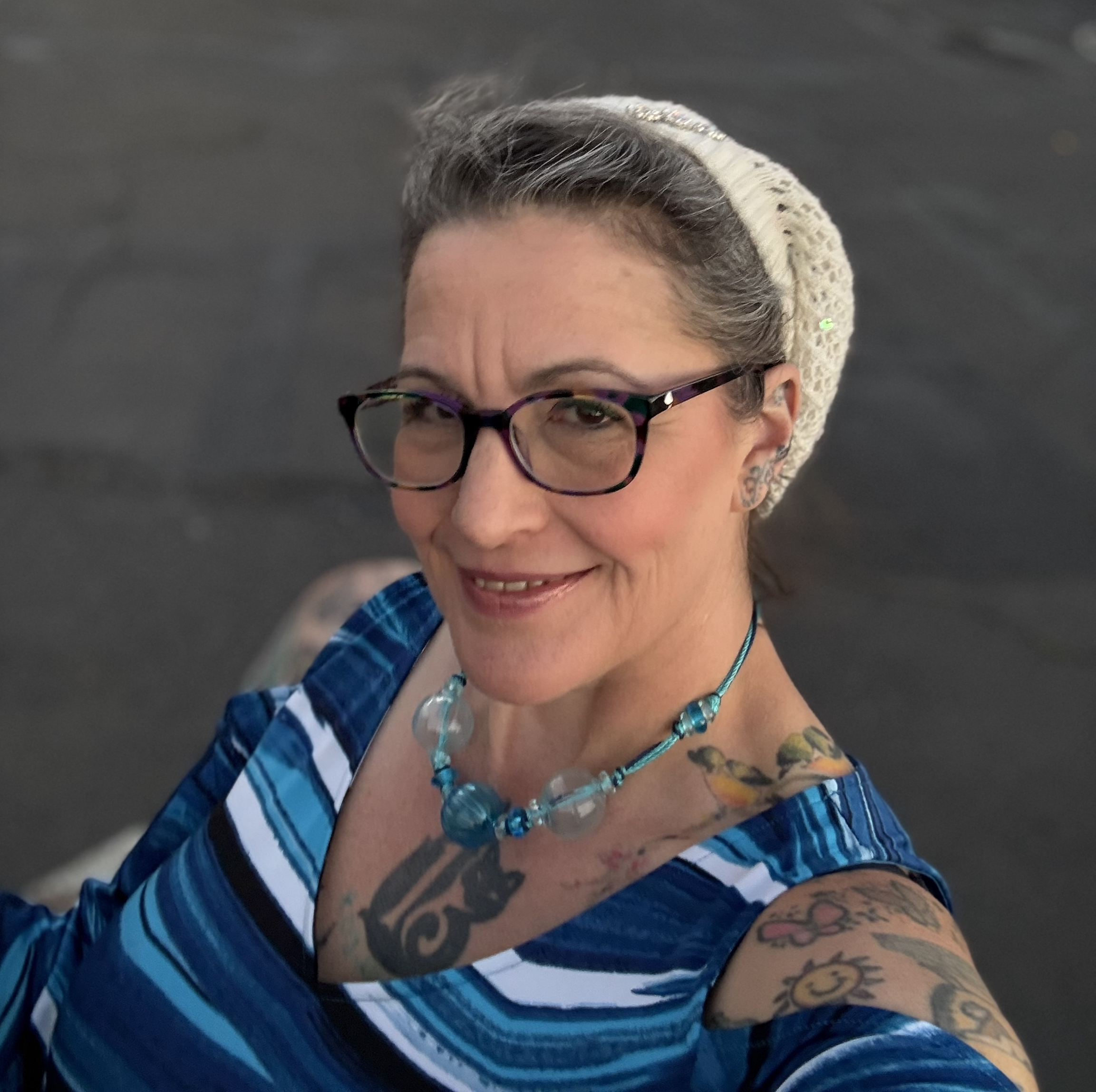 Violet smiling outdoors in a blue dress, in Cotati, California. Certified Massage Therapist and professional Cuddler.
