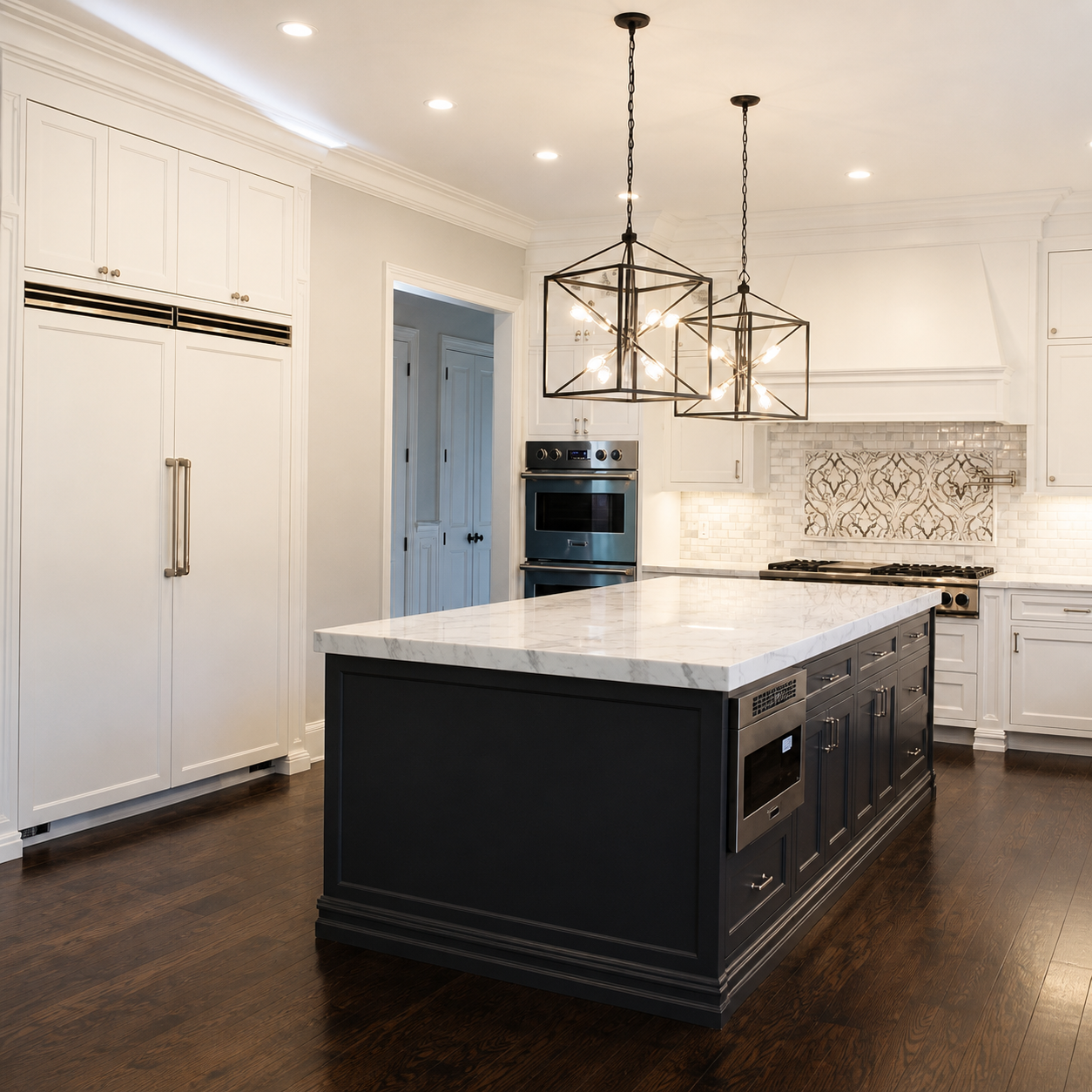 Modern kitchen with white cabinets, a dark island with a marble top, and pendant lighting fixtures.