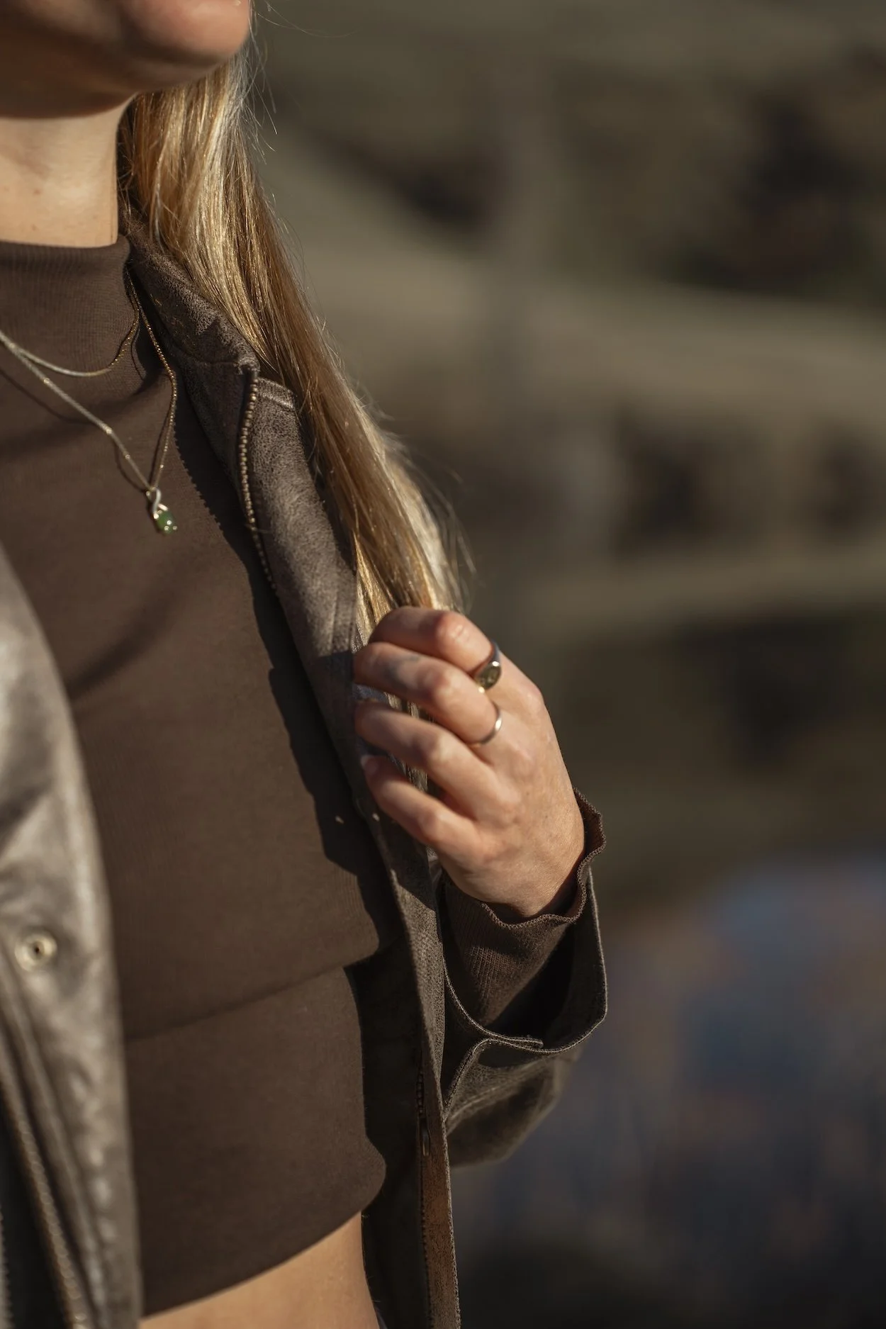 A close up of Kelseys hand holding her jacket.