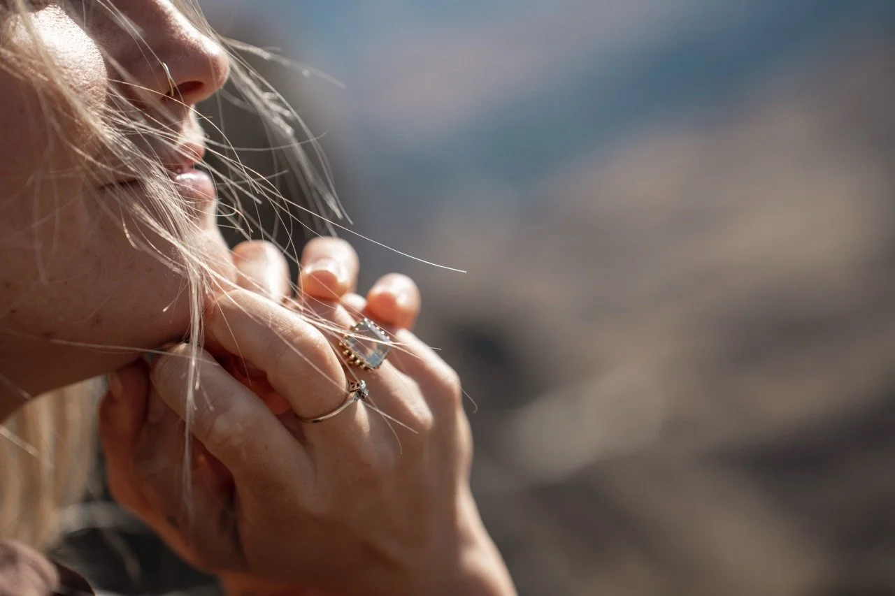 A close up of Kelseys hands resting under her chin.