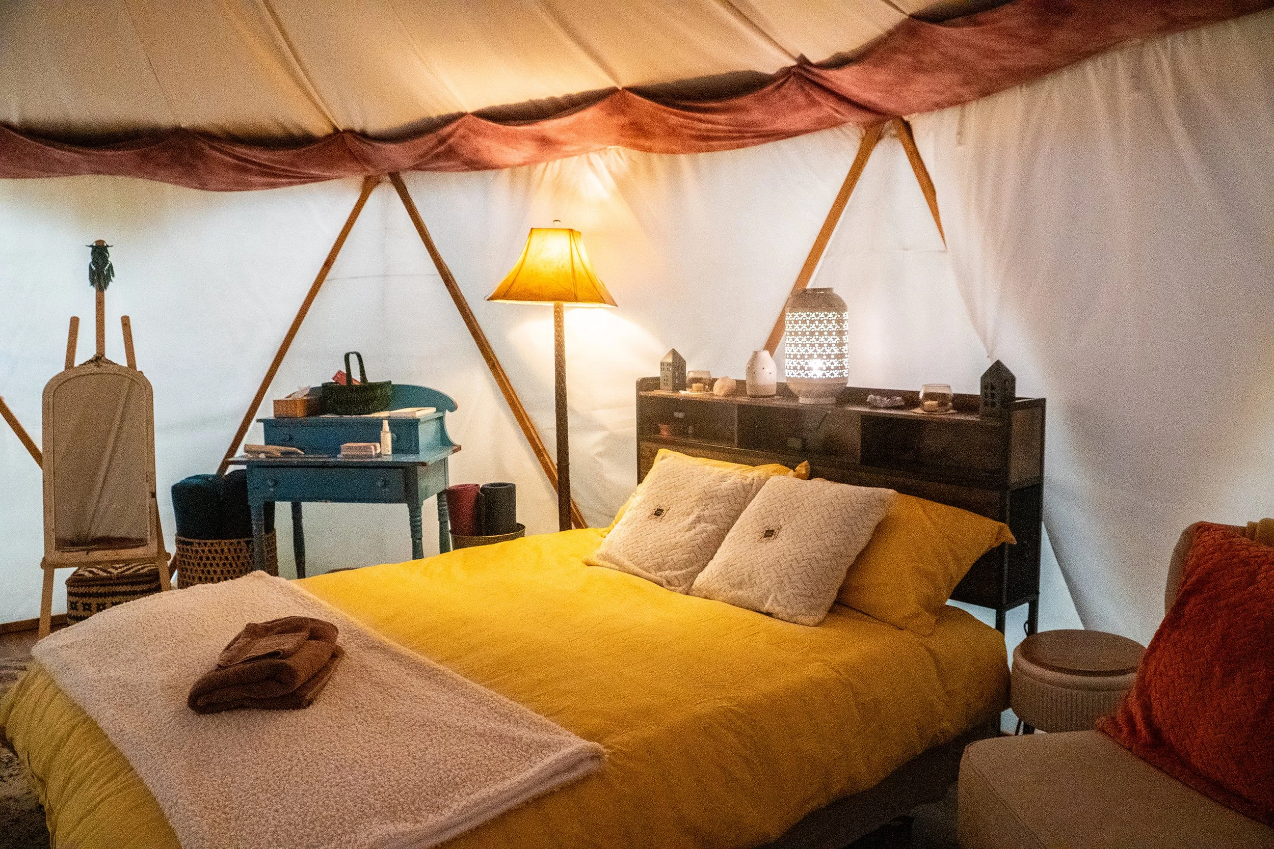 Cozy luxury glamping yurt interior with queen bed