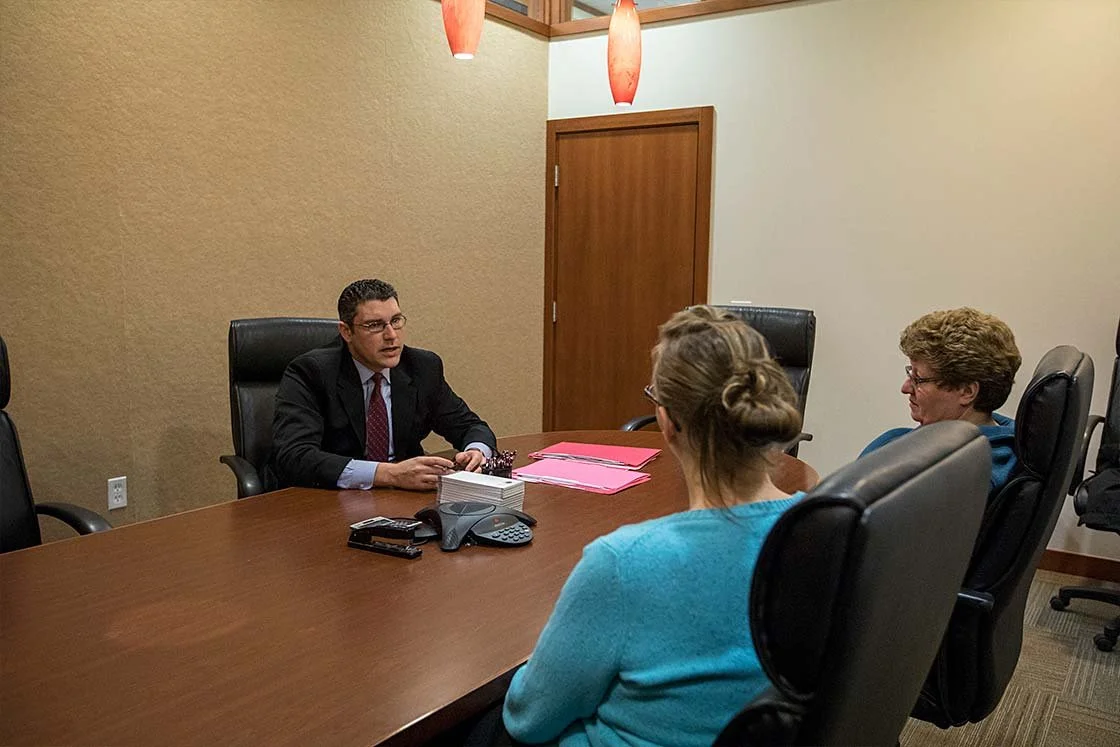 Attorney consulting with clients in a conference room at PDKST Law Firm in Midland, Michigan.