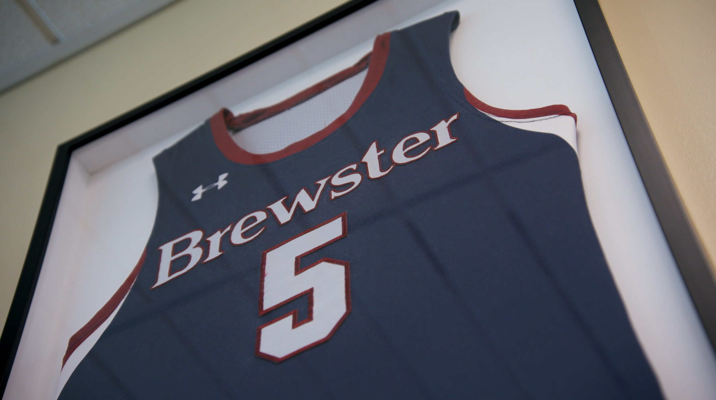 A framed sports jersey with the name 'Brewster' and the number 5, displayed against a white background.