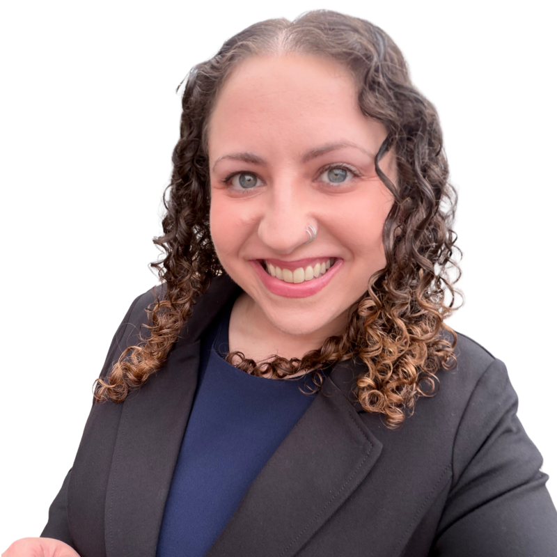 A woman with curly brown hair, blue eyes, wearing a nose ring and black blazer, smiling at the camera.