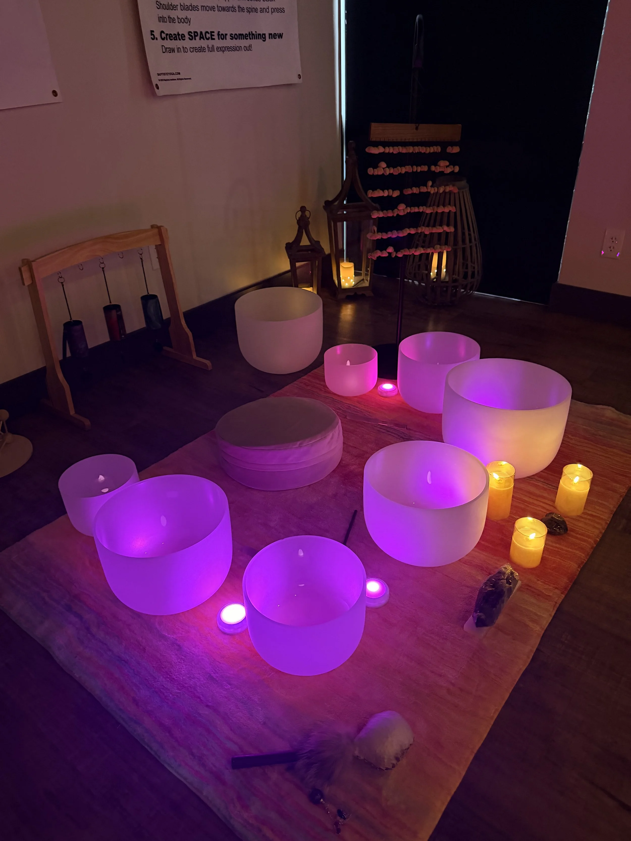 Room with glowing singing bowls, candles, and decorative lanterns for relaxation or meditation.