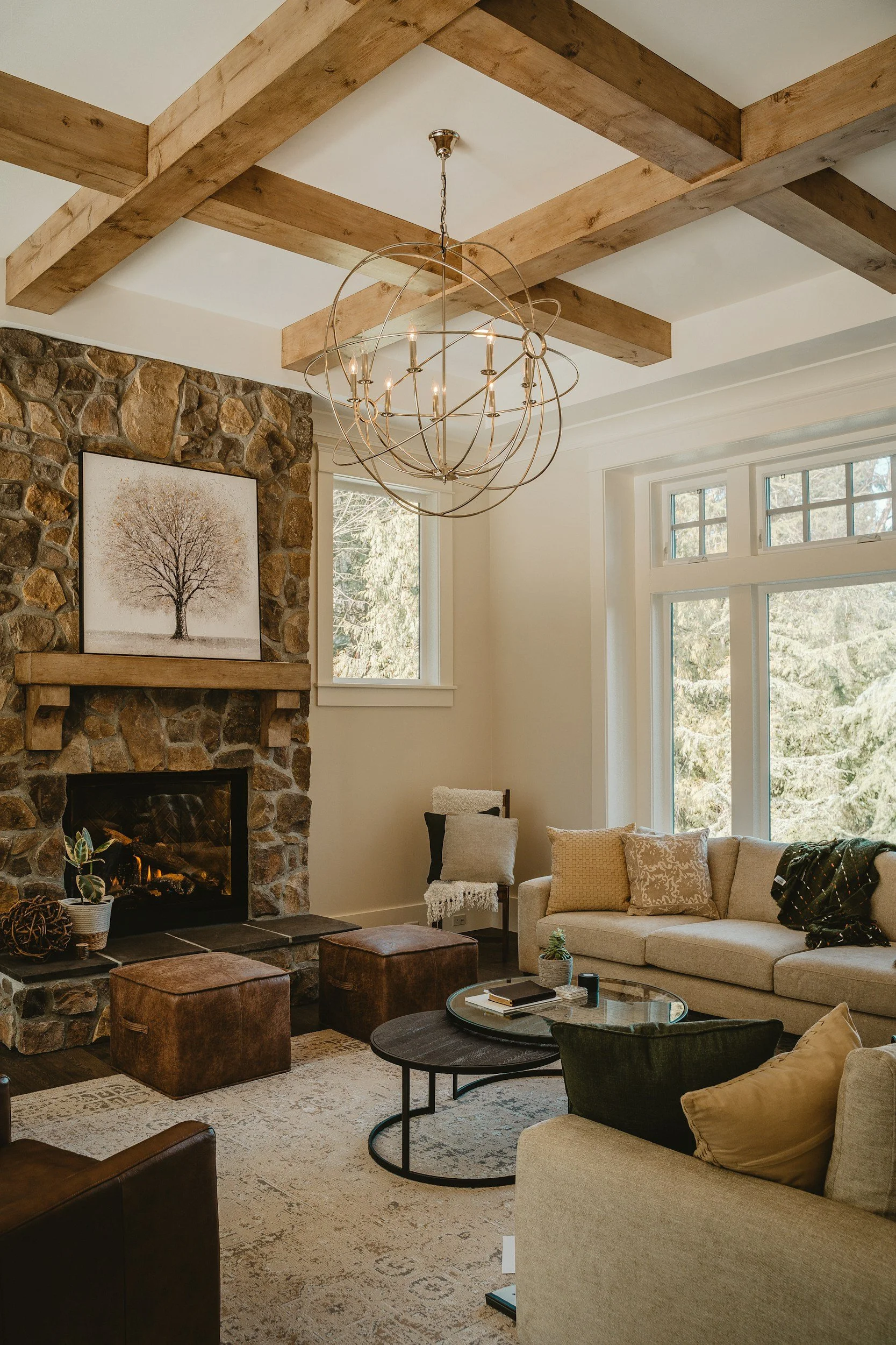 rustic and cozy living room remodel with rustic stone fireplace, exposed wood beams, and a beautiful chandelier with a perfect balance of natural lighting and warm tones