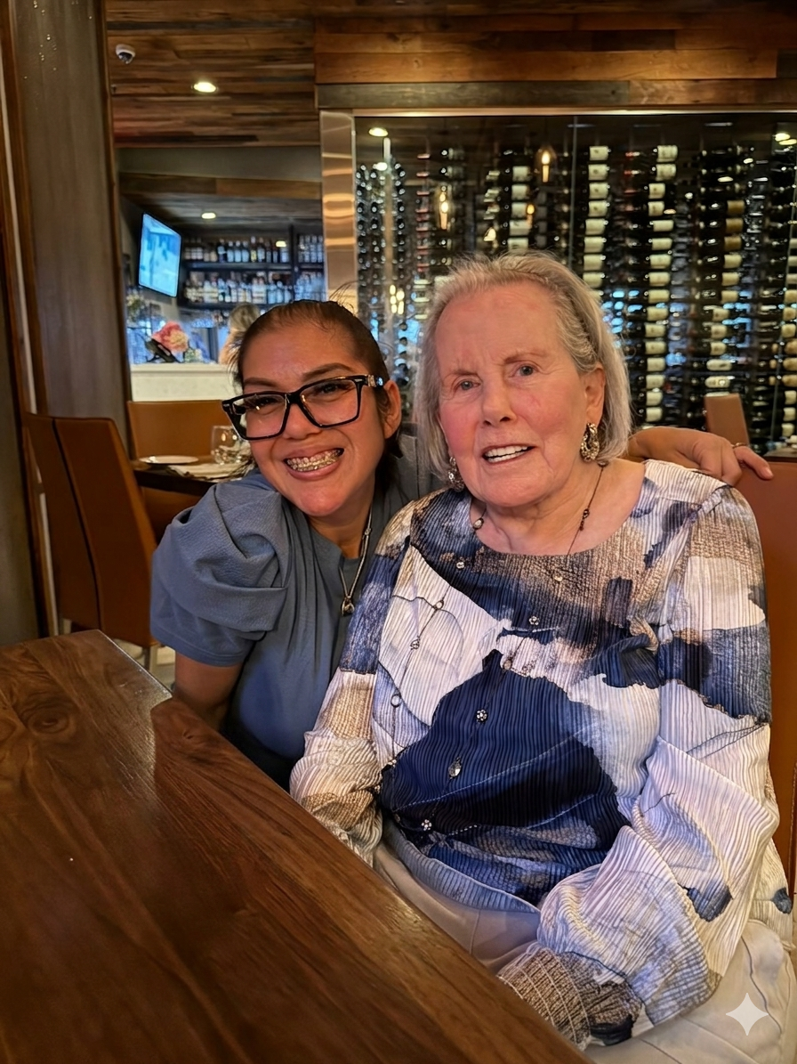 Two smiling women in a restaurant, enjoying each other's company.
