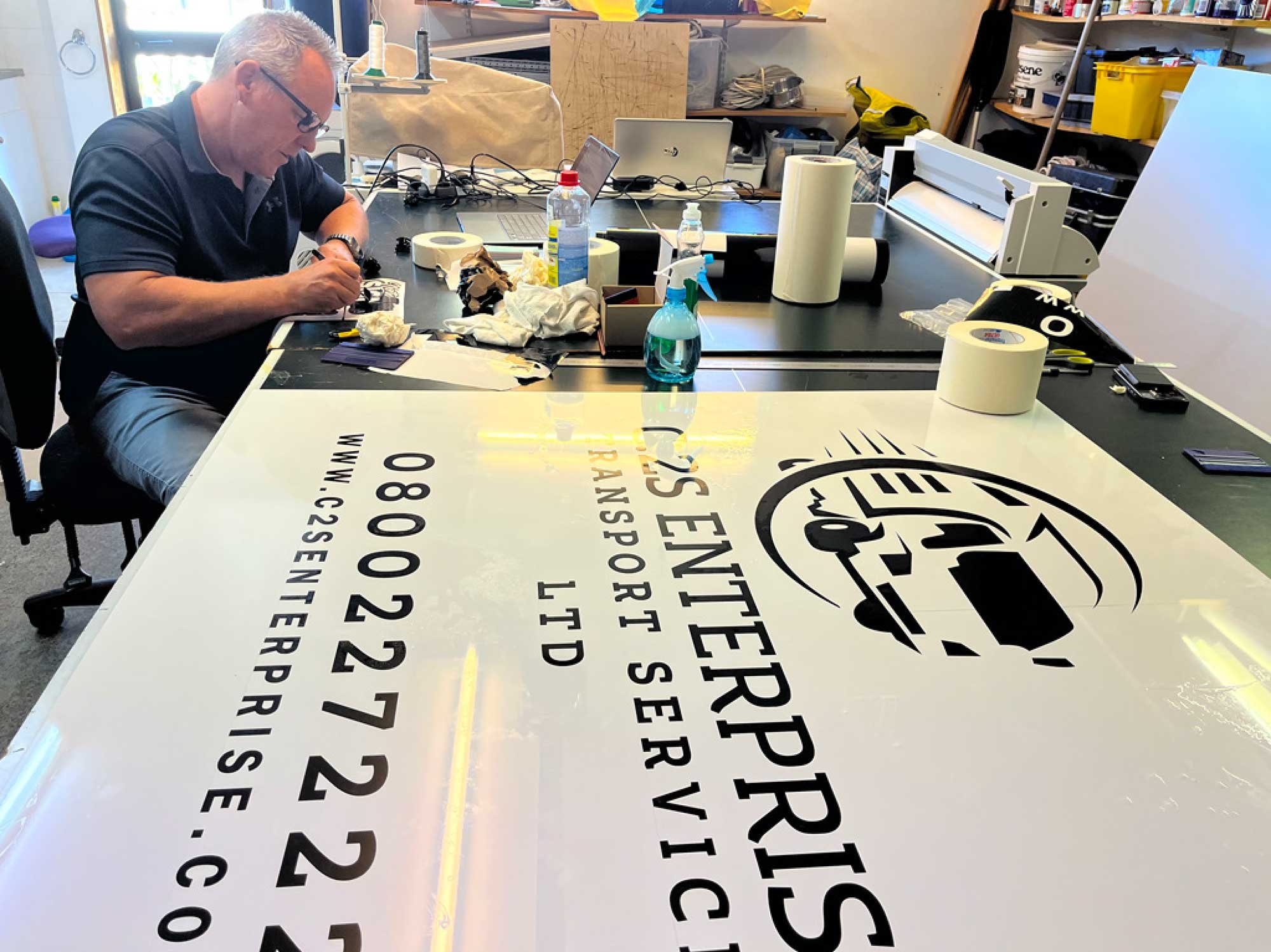 Signwriting ACM board in workshop, C2S Enterprise