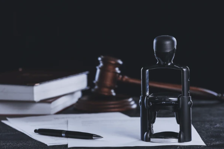 Legal desk scene with gavel, contract stamp, pen, documents, and books.