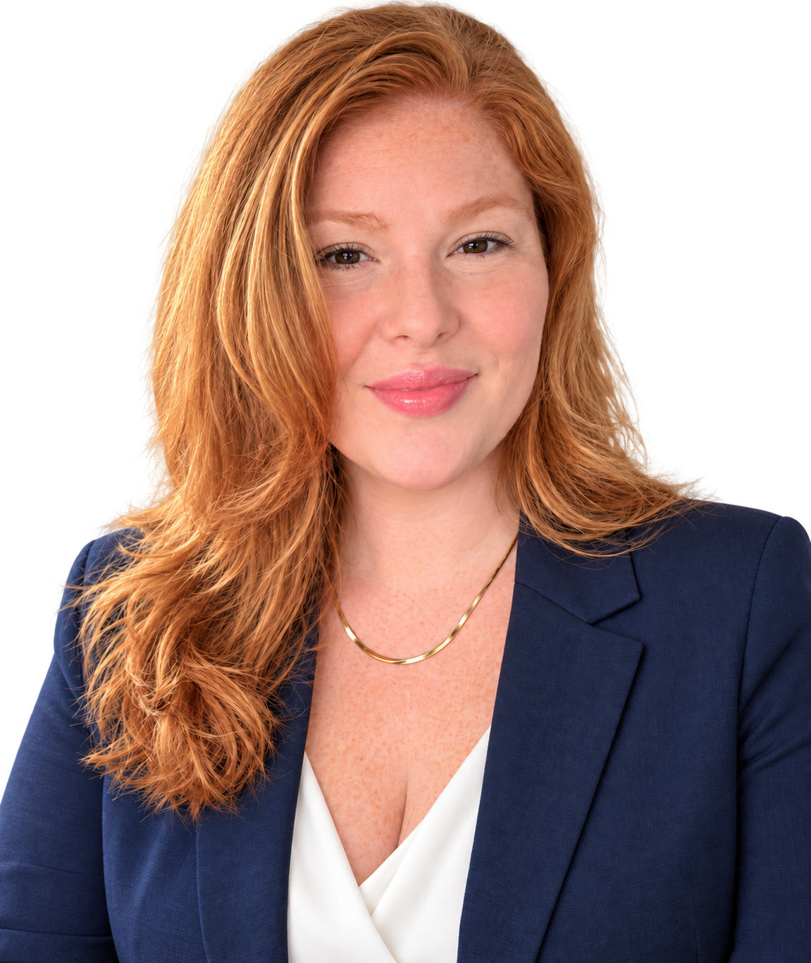 A woman with red hair, wearing a navy blazer and white blouse, smiling at the camera.
