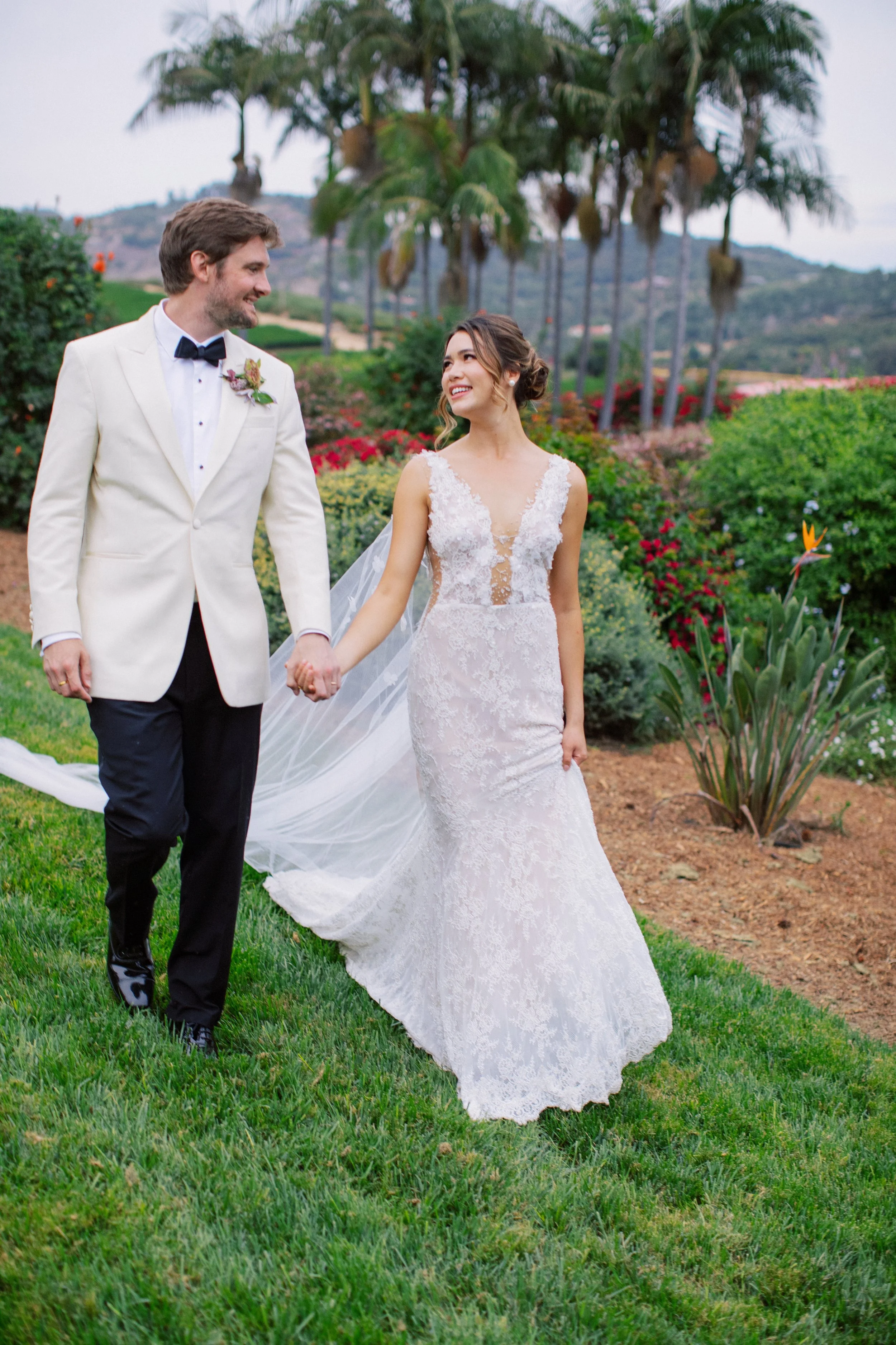 Bride and groom walking together through Rancho Vera Cruz wedding venue grounds in Oceanside California