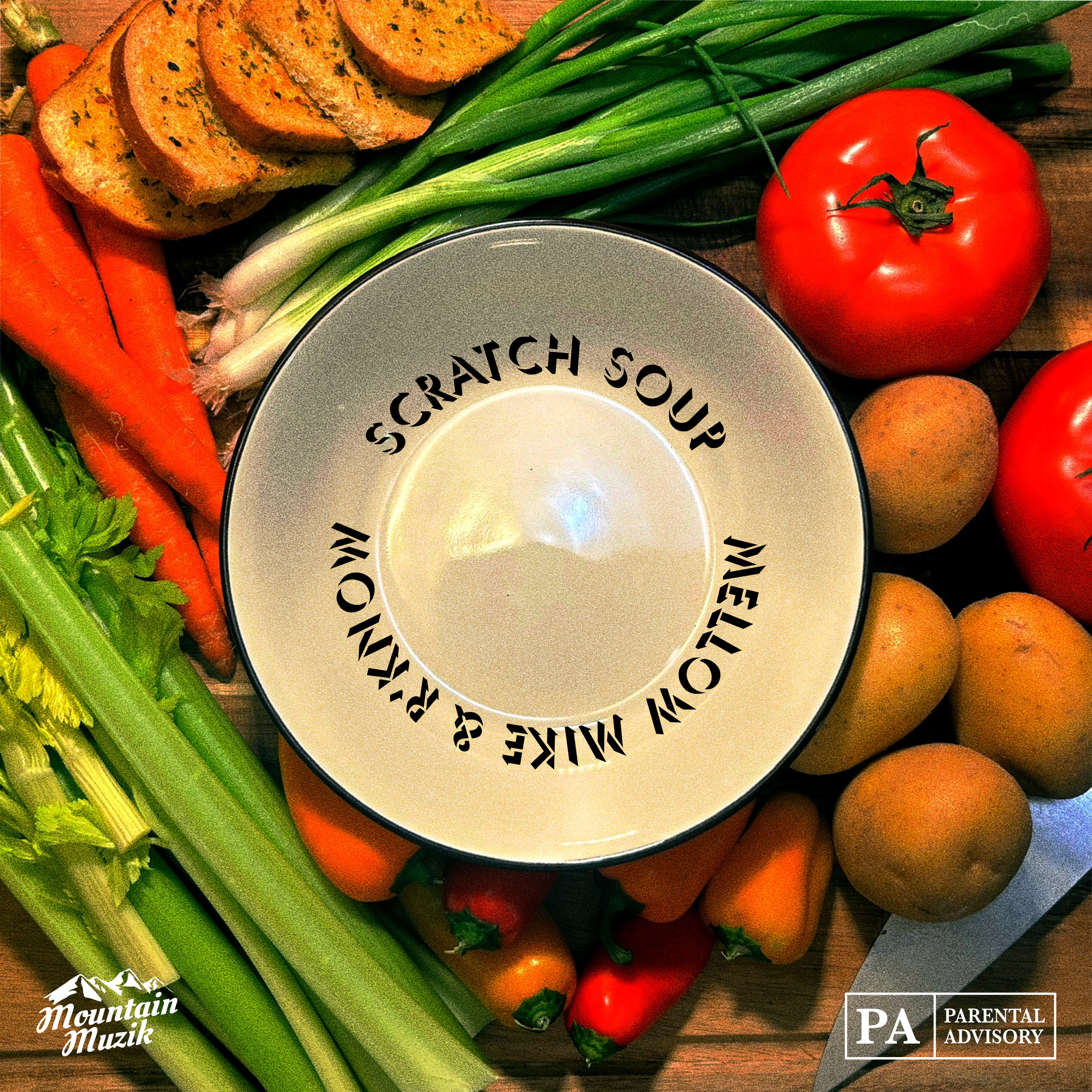 An assortment of fresh vegetables including carrots, green onions, cherry tomatoes, celery, and a few slices of garlic bread, arranged on a wooden surface with a ceramic bowl in the center that has the text "Scratch Soup" by Mellow Mike & R'Know.