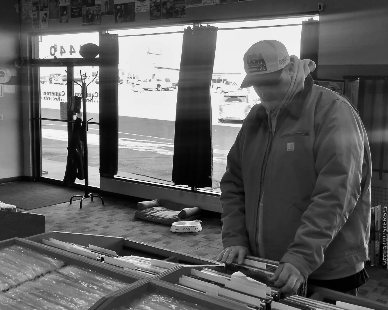 Mellow in a record store, searching through various vinyl near the store window.