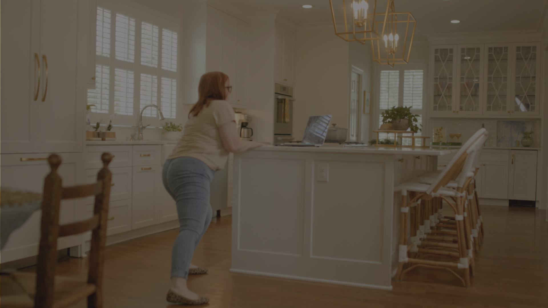 Woman in living room on her computer using Mikro Move app
