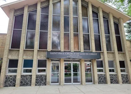 Facade of Saint Paul Church of God in Christ with large windows and stone accents.