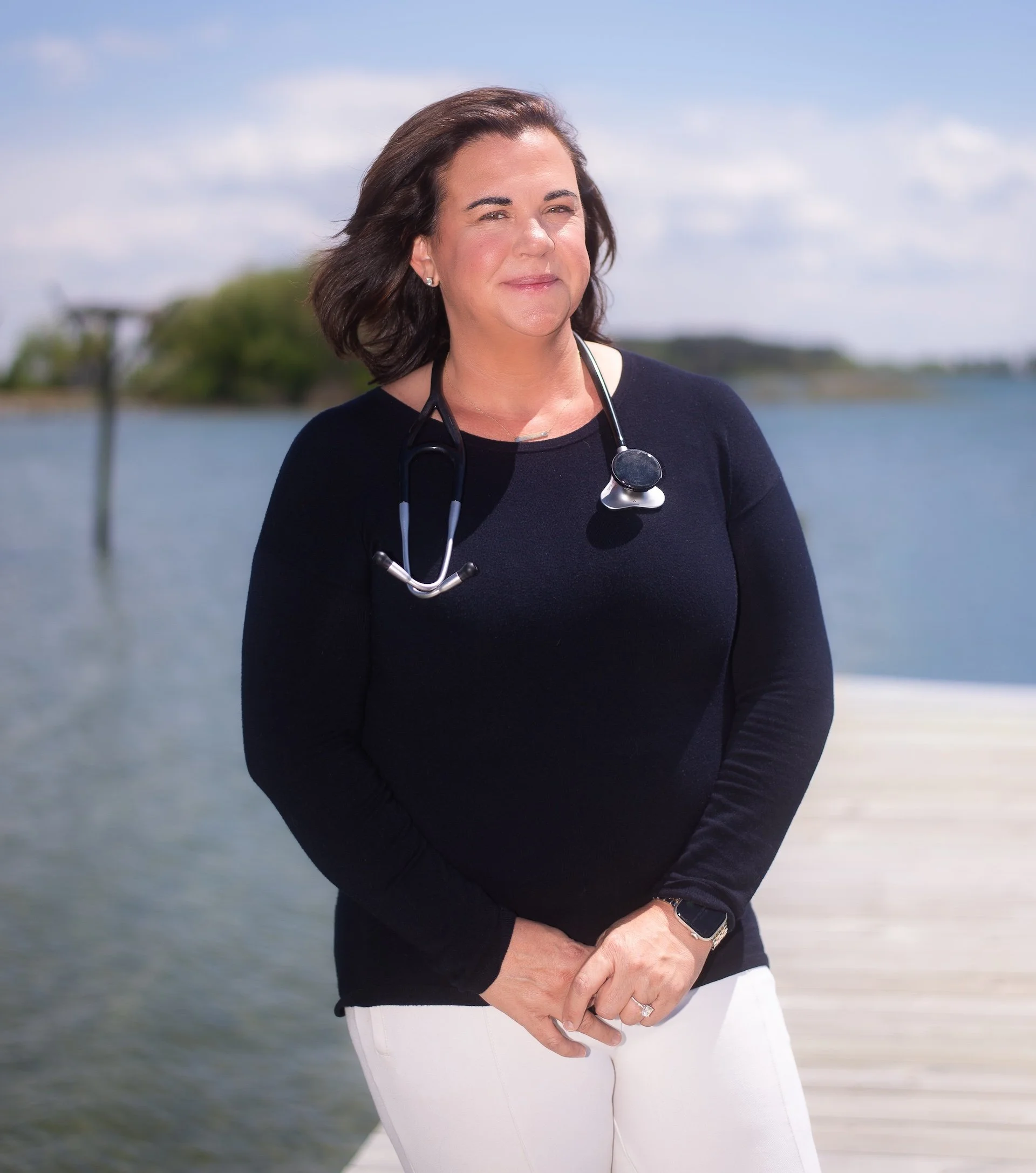 A portrait of Valerie Wallace standing on a dock by the Chesapeake Bay