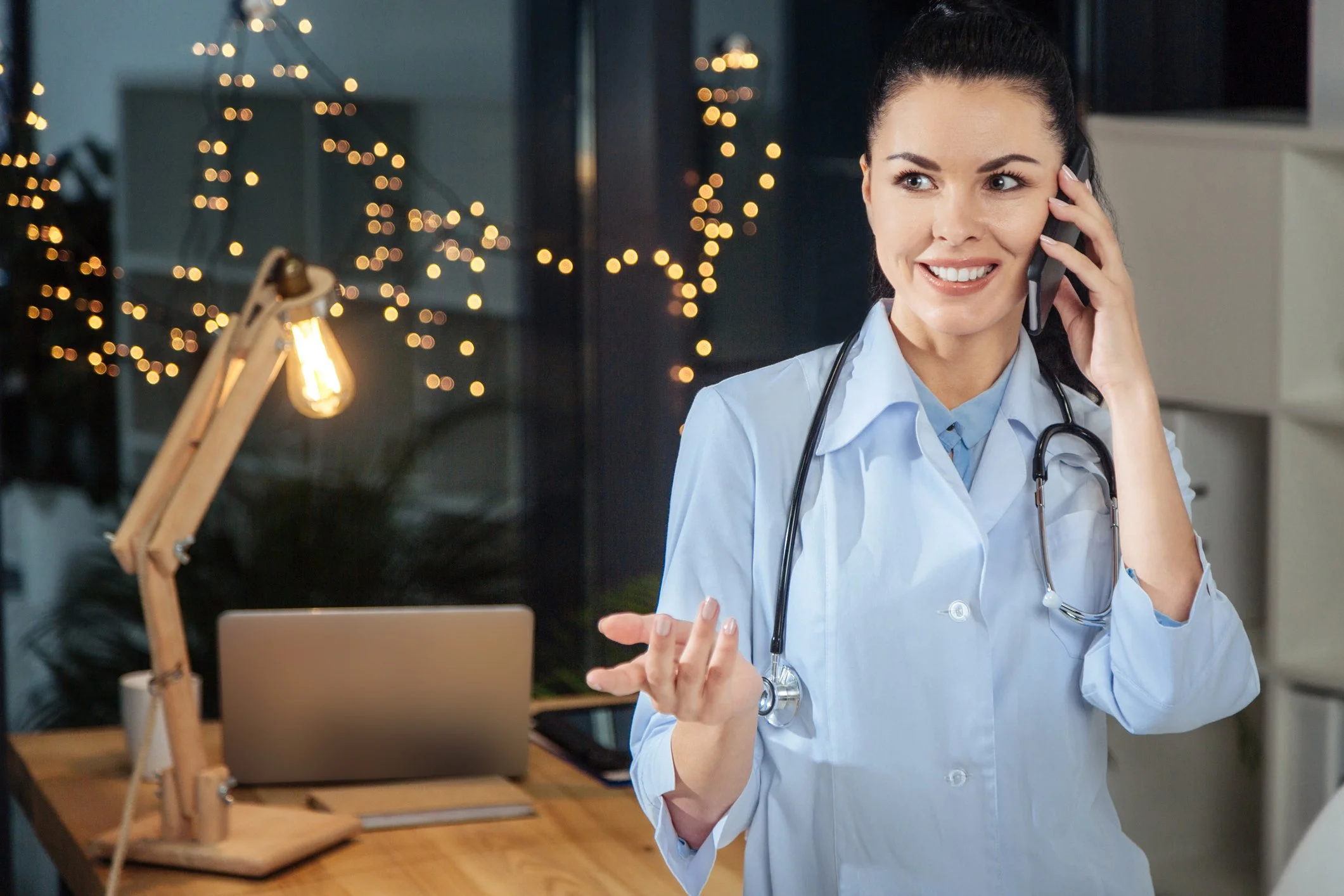 A provider speaks on the phone with a patient while sitting at her desk