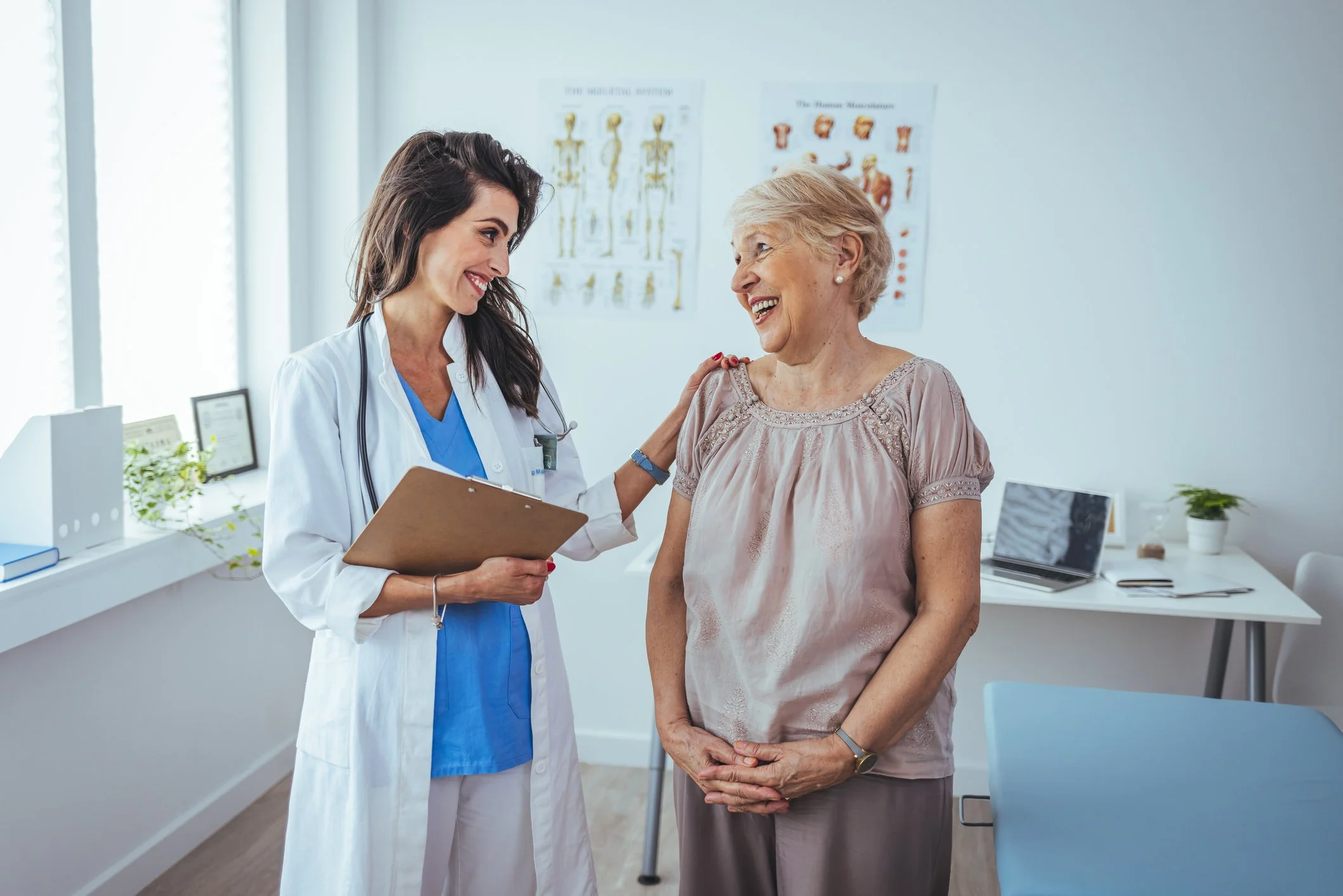 A female provider smiles at patient while holding a clipboard