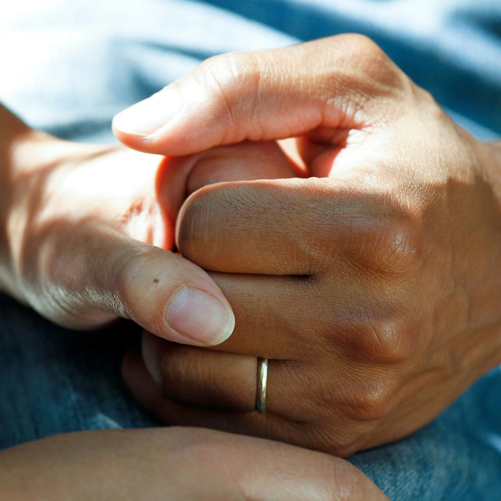 A family member clasping a patient's hand