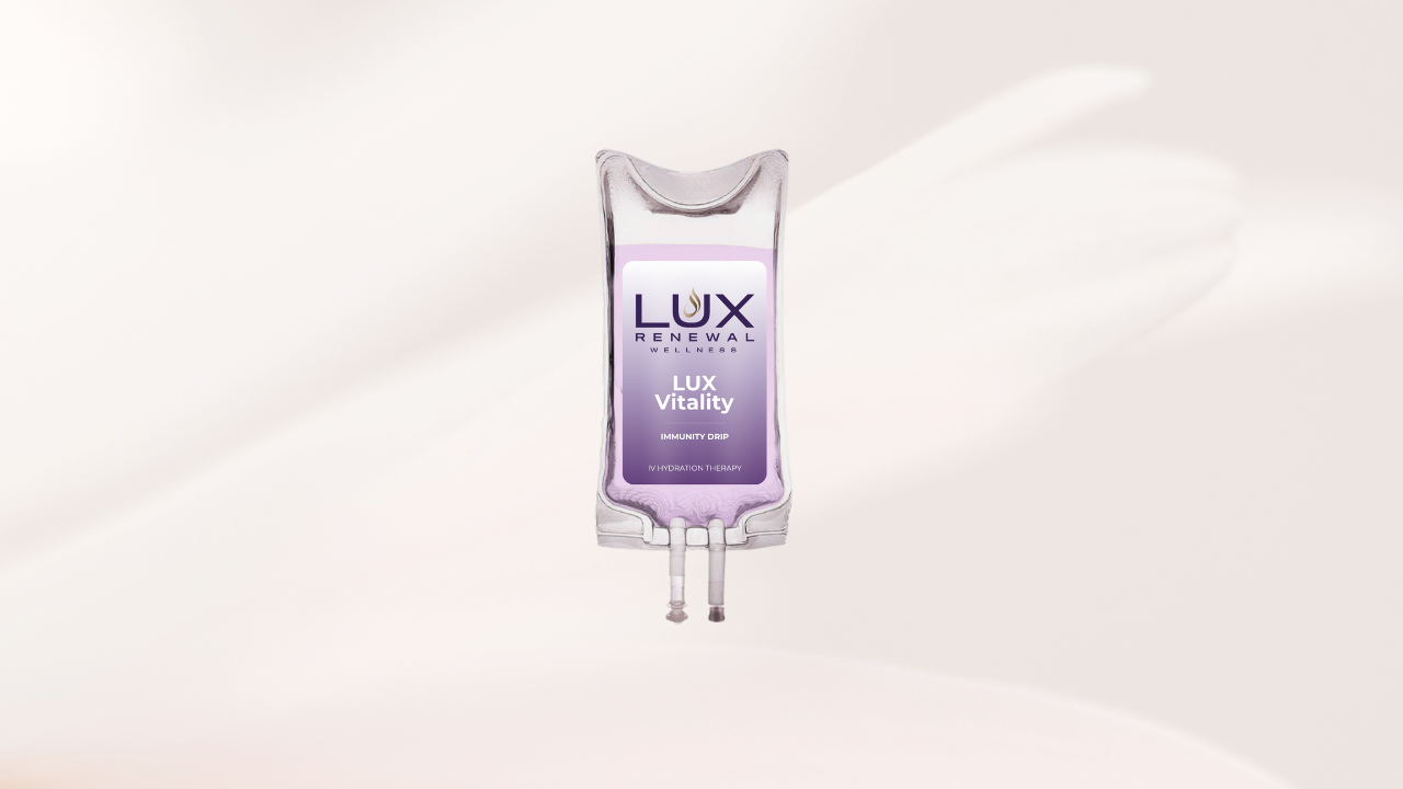 A clear IV drip bag with a purple label reading 'LUX Wellness, LUX Vitality, Immunity Drip, IV Hydration Therapy' against a light, neutral background.