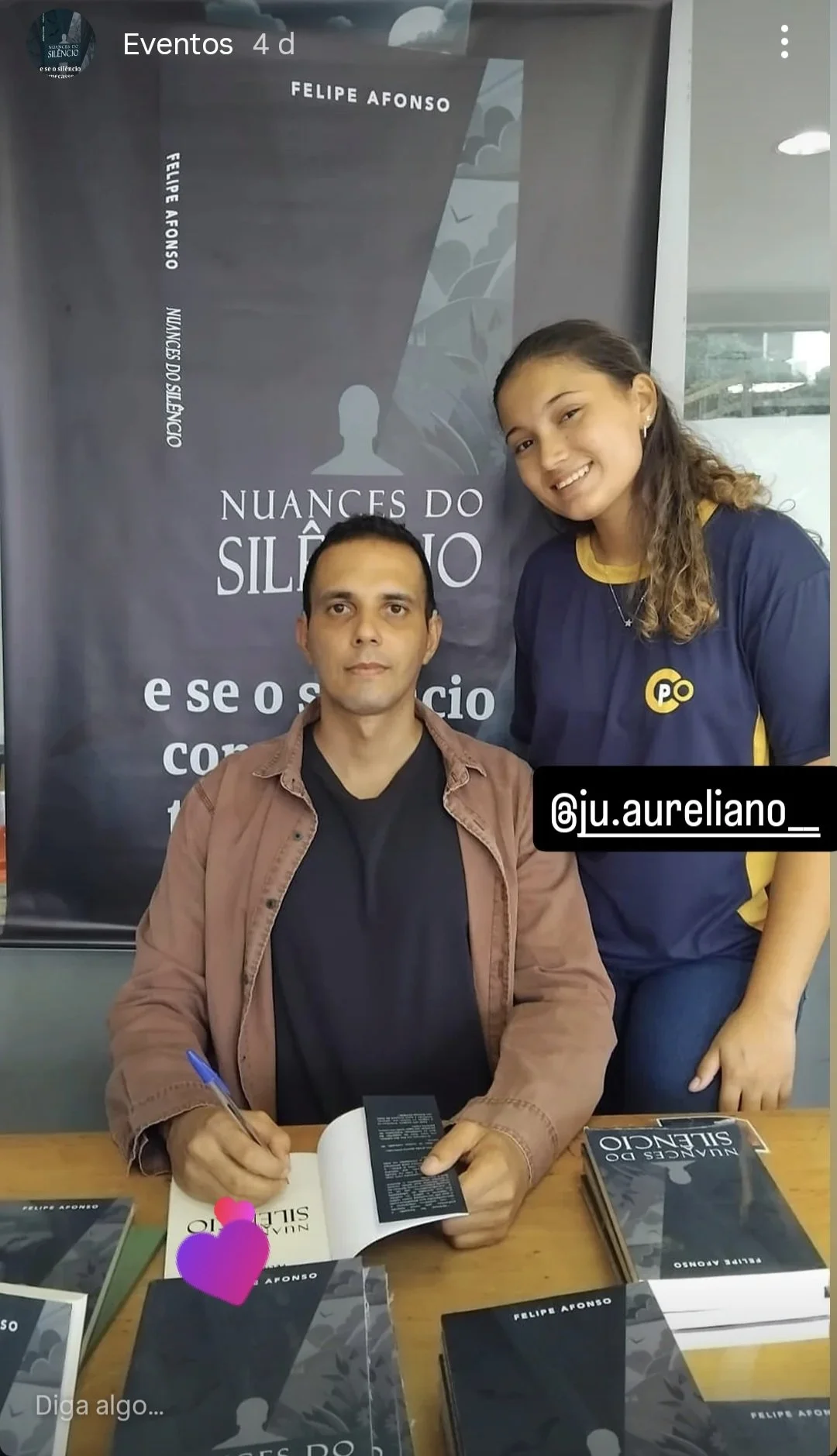 Autor Felipe Afonso autografando o livro de uma leitora