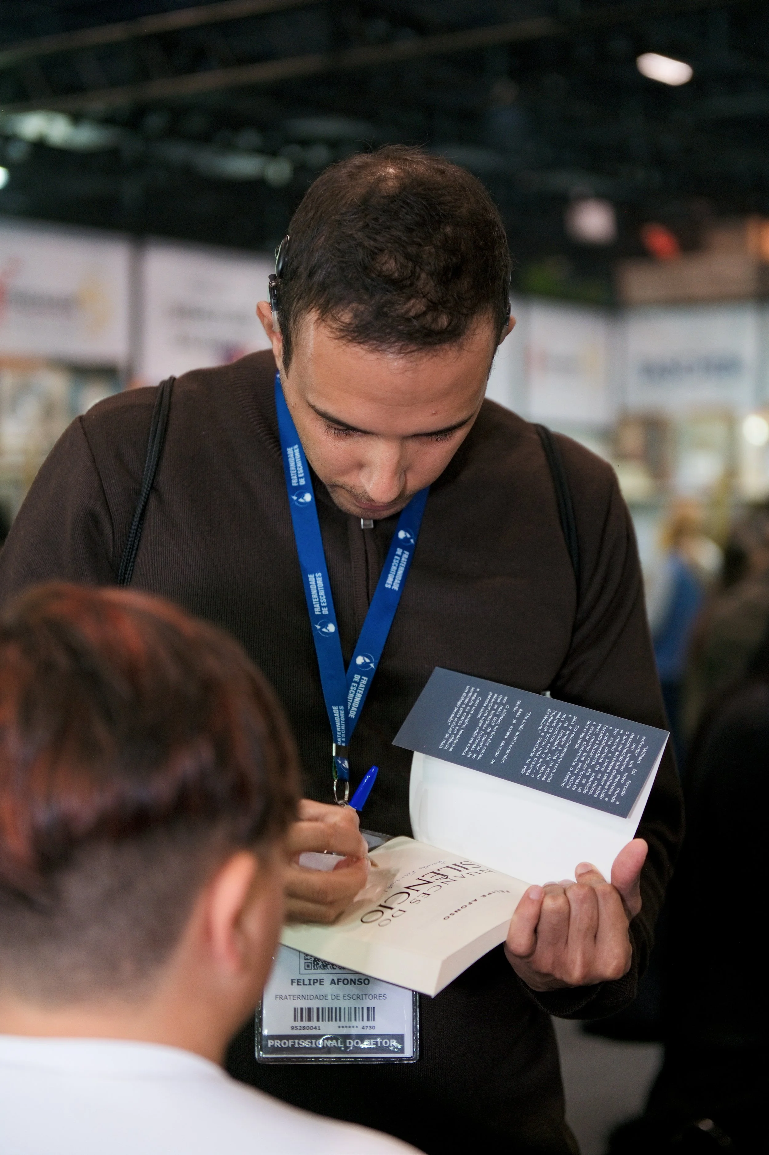 Autor Felipe Afonso autografando livro Nuances do Silêncio na Bienal do Livro 2026