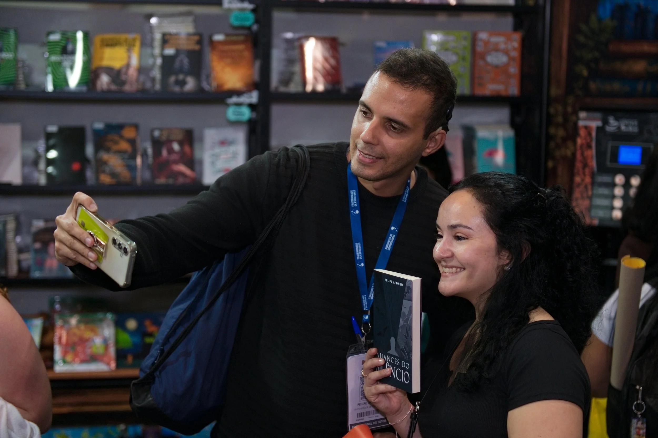 Autor Felipe Afonso tirando selfie com leitora de Nuances do Silêncio durante Bienal do Livro 2026