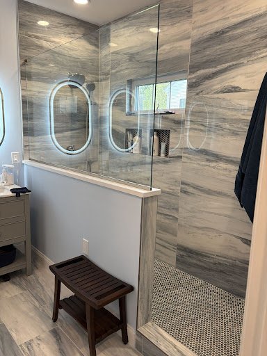 Bathroom remodel with new tile, mirrors, and walk in shower.