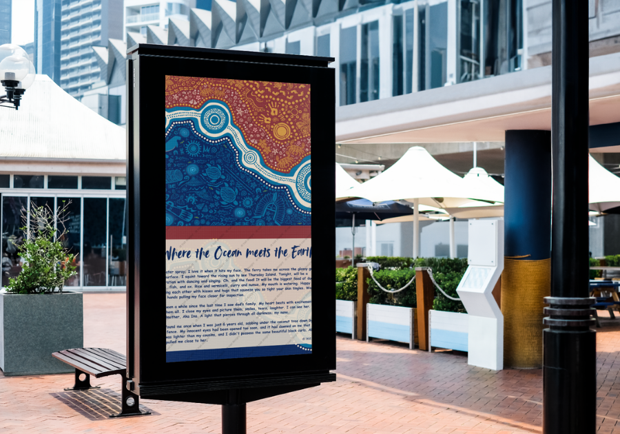 Outdoor digital billboard displaying colorful abstract art and textual information with a title 'Where the Ocean meets the Earth' in a plaza with benches, plants, and modern architectural structures. First Nations, Aboriginal, Torres Strait Islander